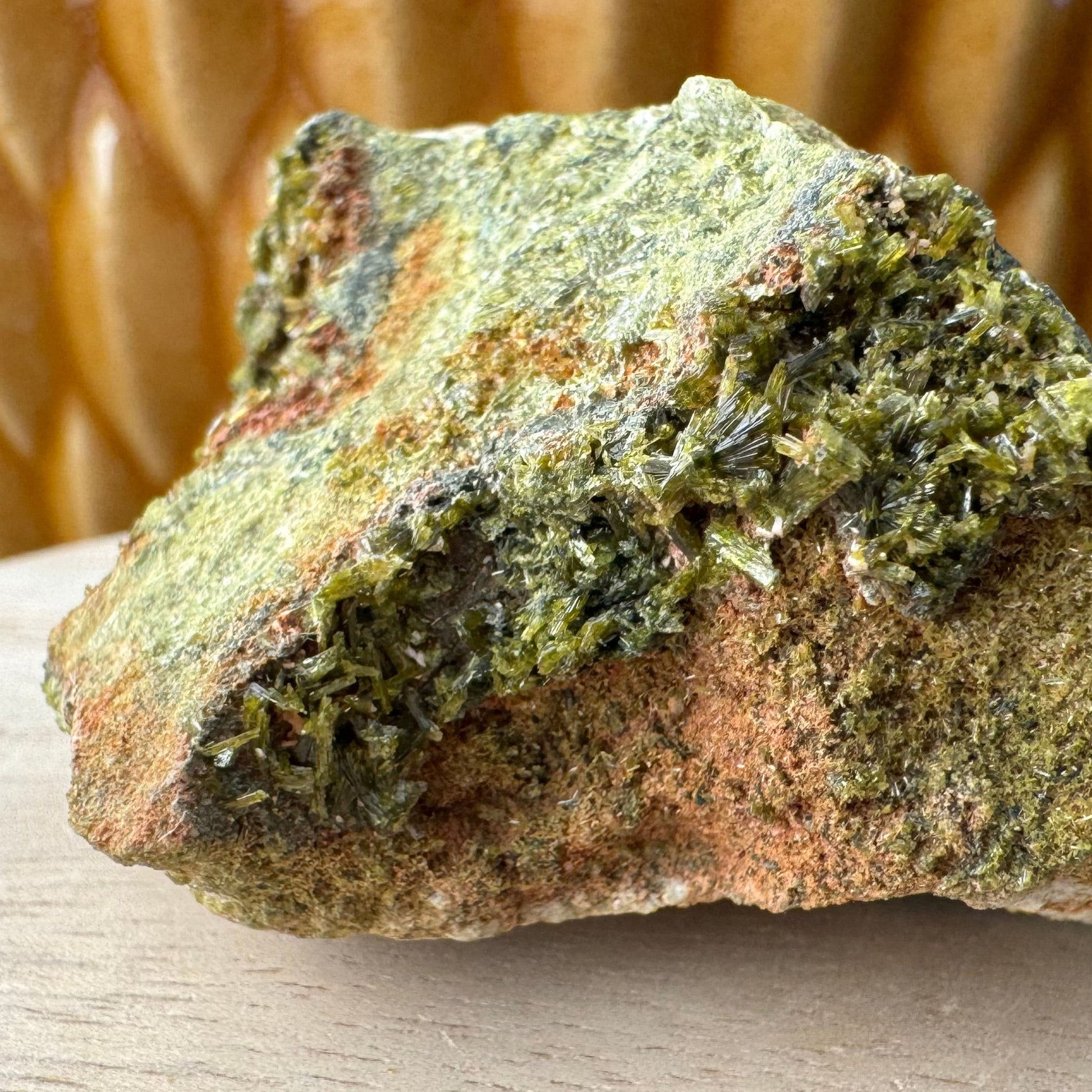 Detail of epidote crystals on one end of the specimen, with partial sprays and bowties of dark green crystals.