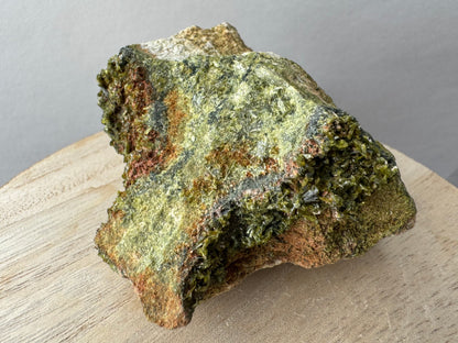 Detail of the top of the specimen, with radial patterns of epidote crystals visible in the green matrix. The edge has thick epidote crystals of moderate quality, many are partial.