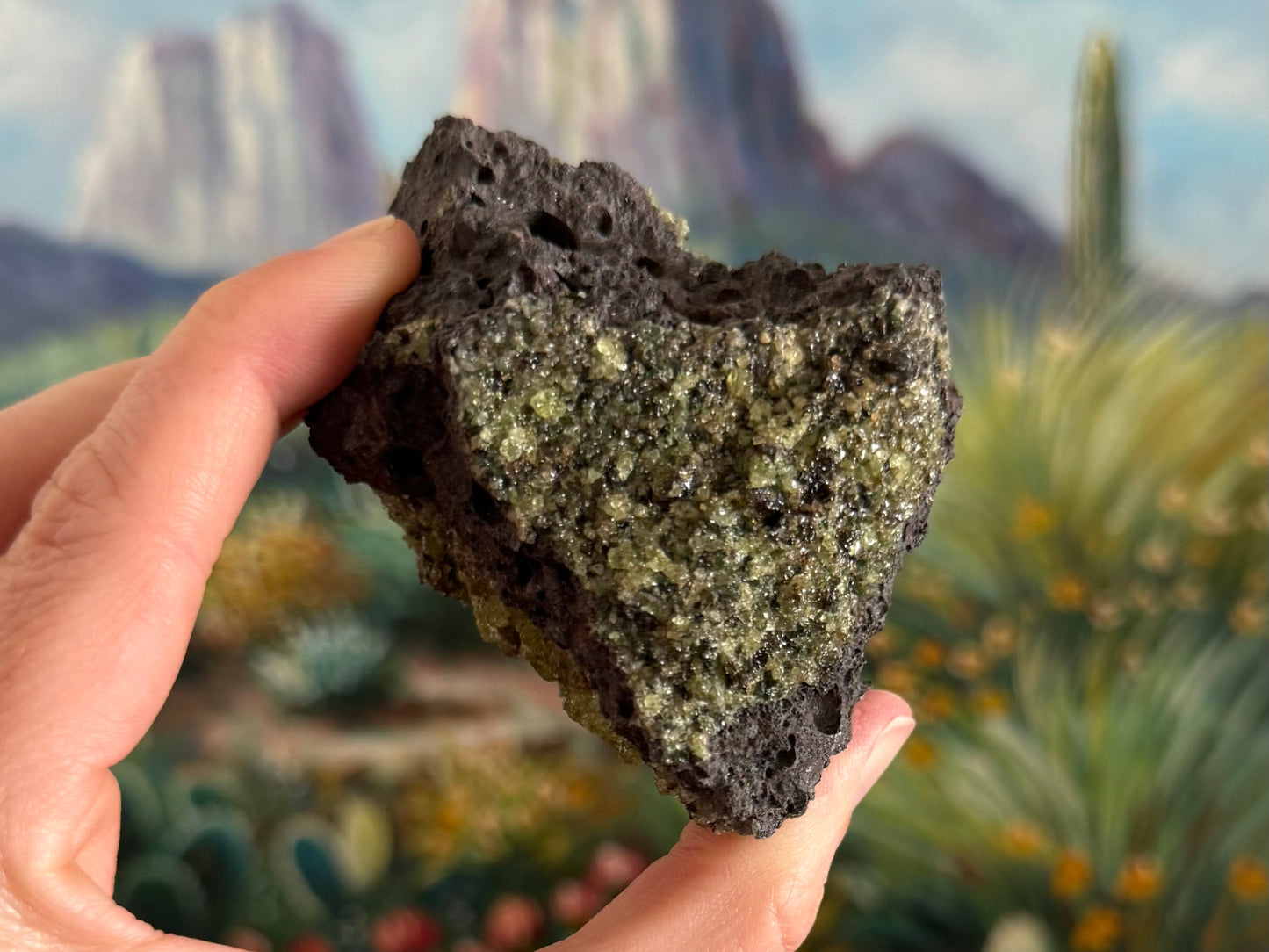 A triangular side of the piece covered with a desaturated yellow-green peridotite with dark green spots of spinel and diopside