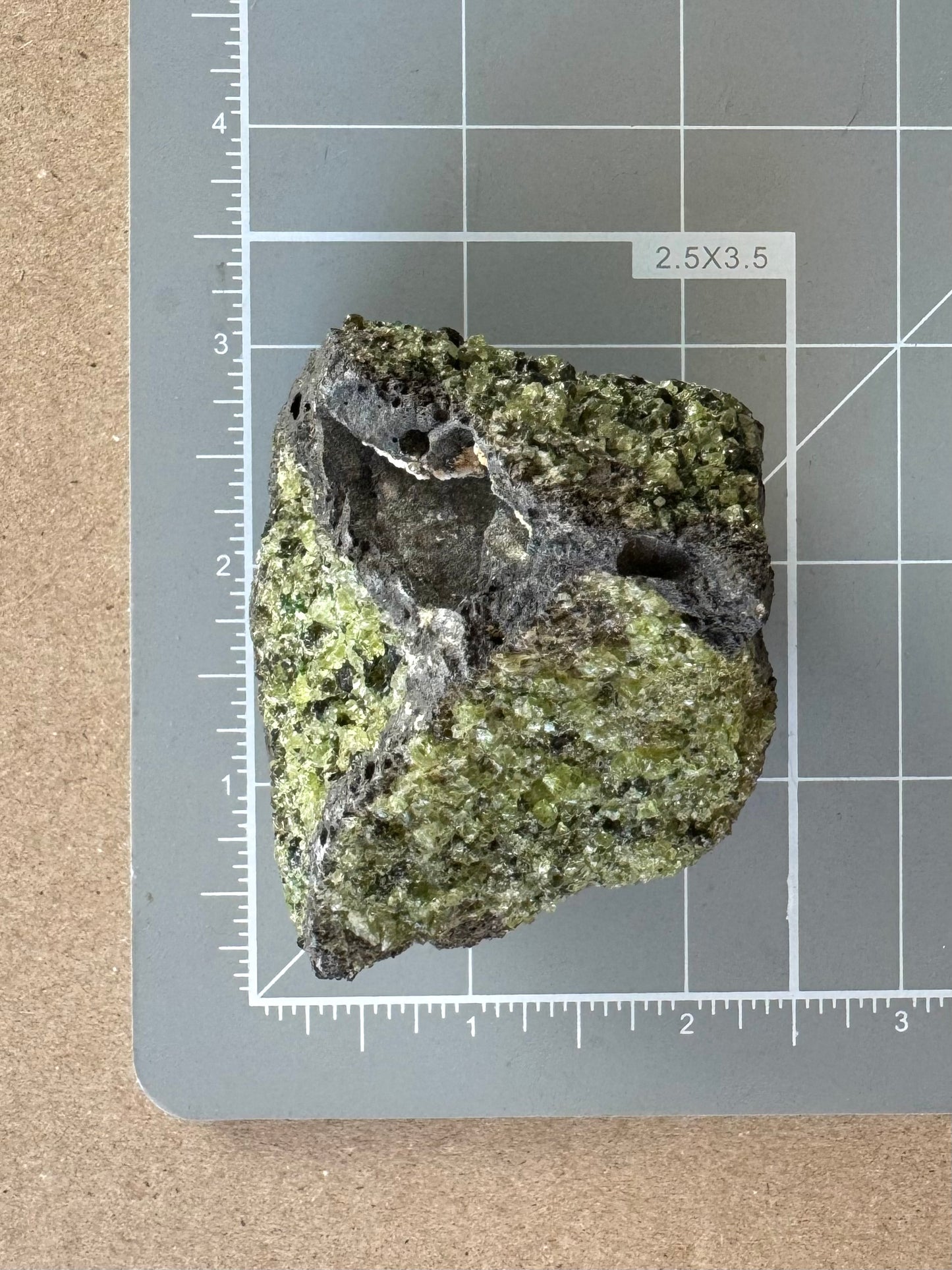 Scale image of the piece on a measuring mat, measuring about two inches tall and over an inch and a half wide