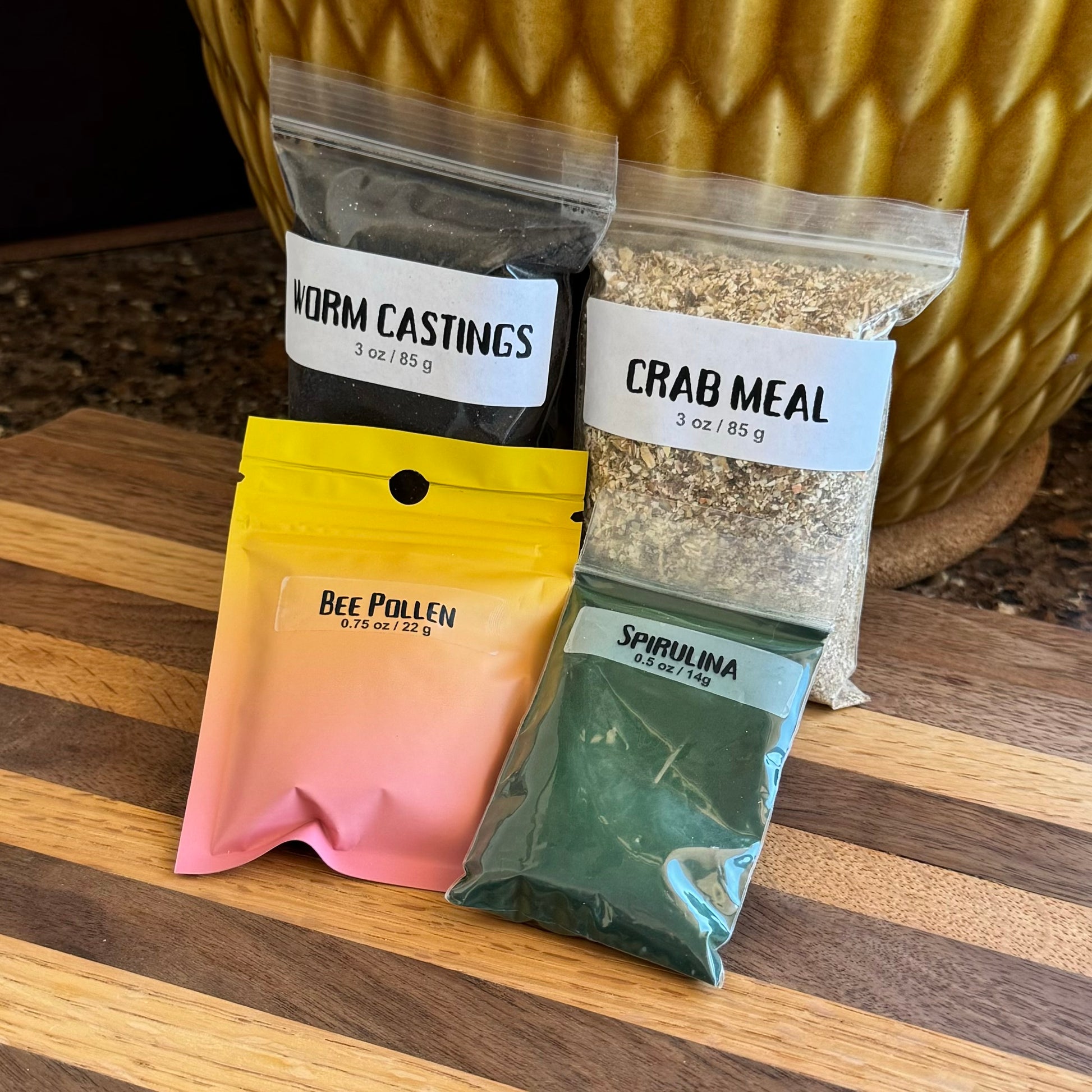 One of each of the bags from the previous images: worm castings, crab meal, bee pollen, and spirulina. The bee pollen and spirulina are in smaller bags than the other foods.