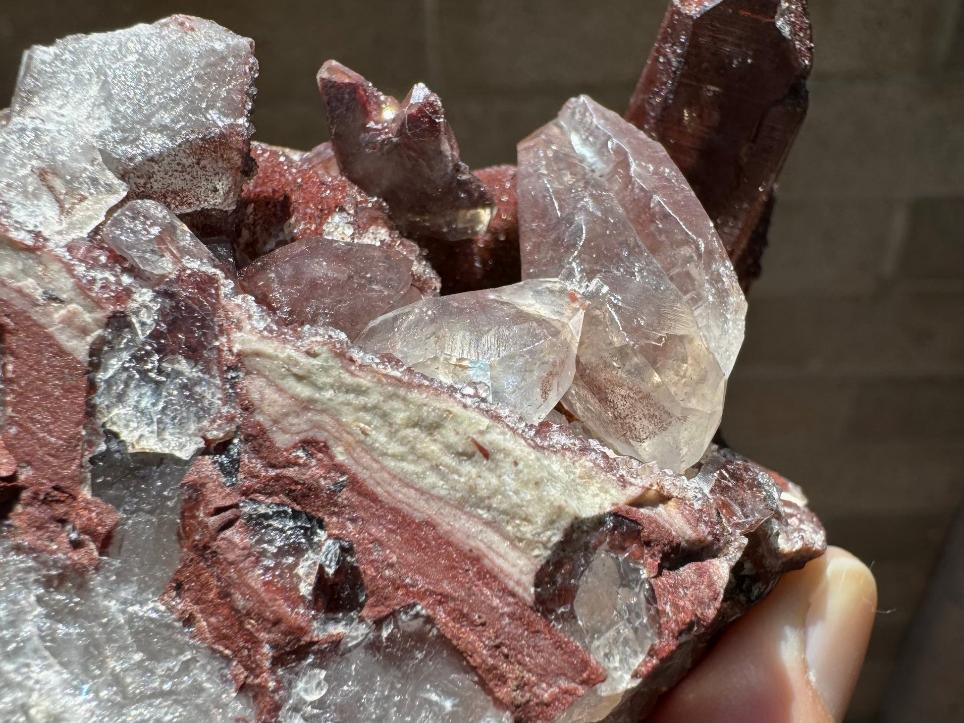 Detail of colorless quartz crystals on the piece, and bacon-fat layers of red and cream agate along the edge of the matrix before it turns to a colorless quartz aggregate. 