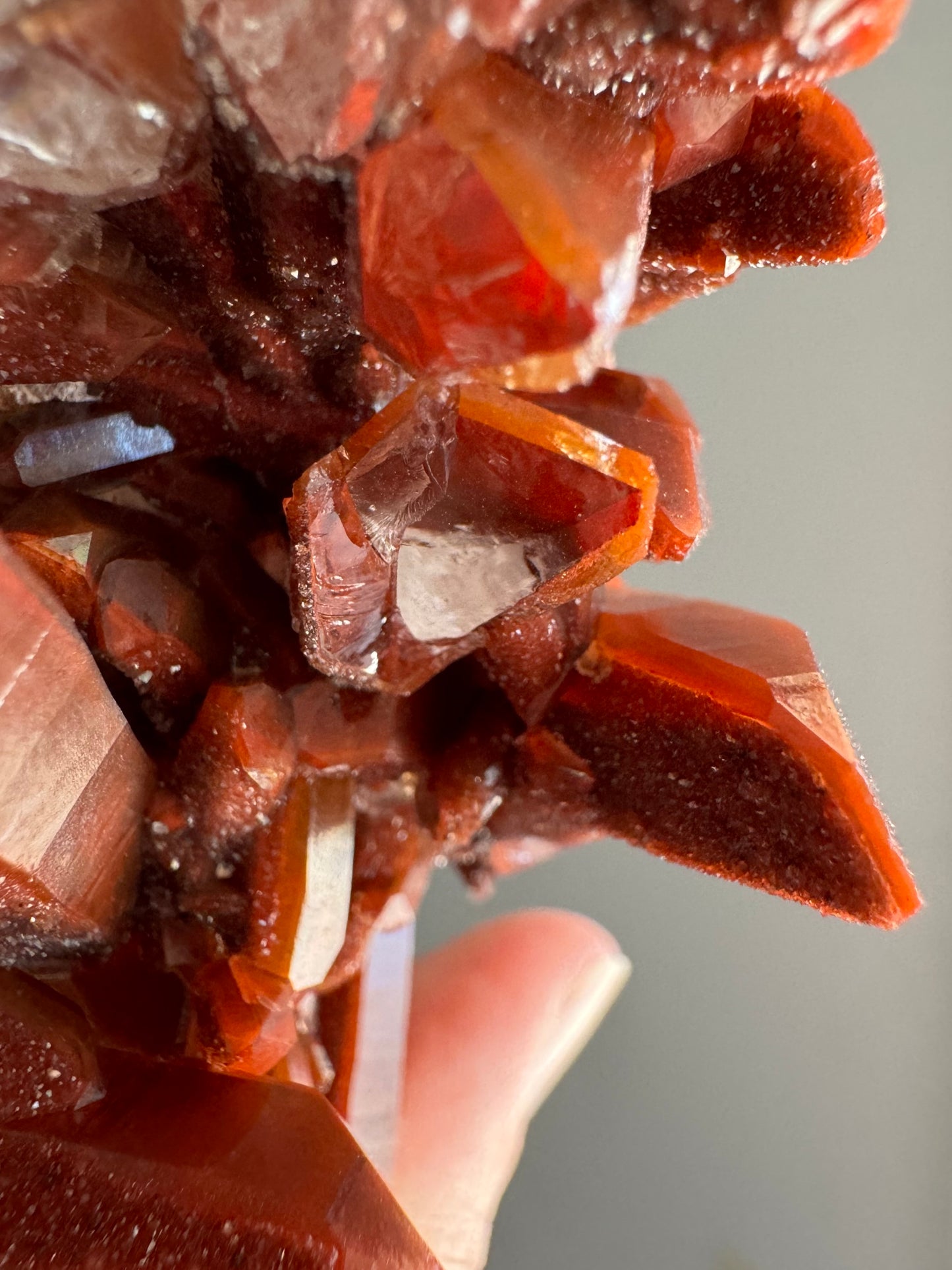 Detail looking down a broken crystal end, crystal clear and colorless in the center with an outer rim of red hematite-included quartz