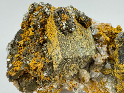 Detail of the large hexagonal barrel crystal, showing unusual clusters of shiny pyrite on the end and side.