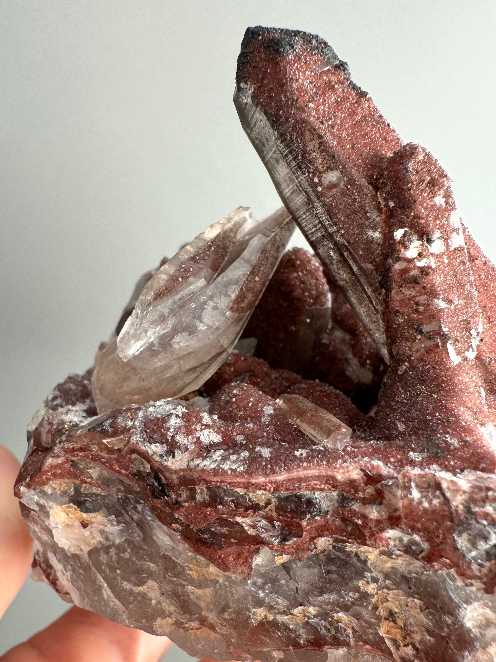 Side-view of the piece showing the thin agate-like layers of the quartz matrix, and the unusual colorless quartz crystals angled on top of the piece.