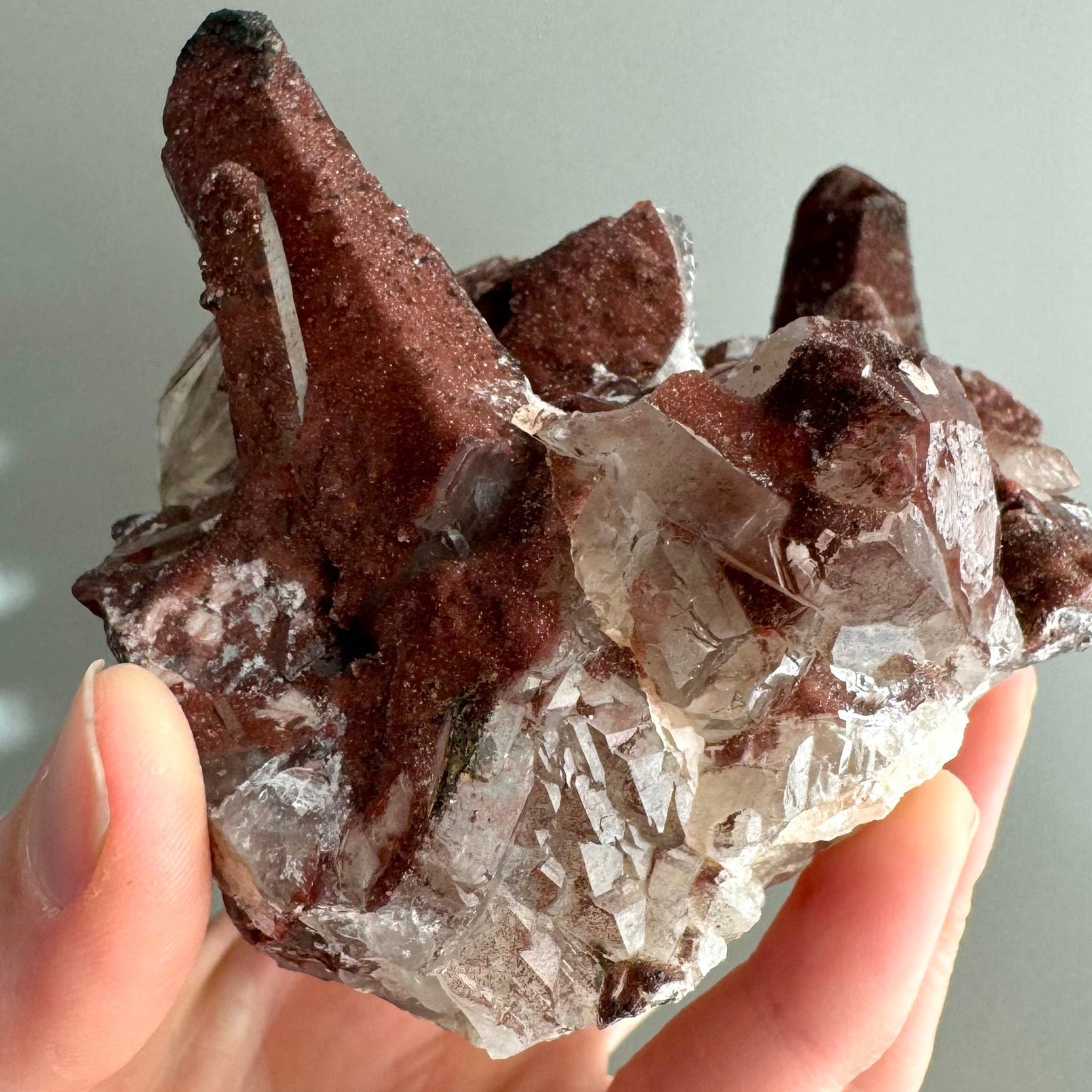 Detail of stepped colorless quartz on the base of the specimen, dusted with small red spots.