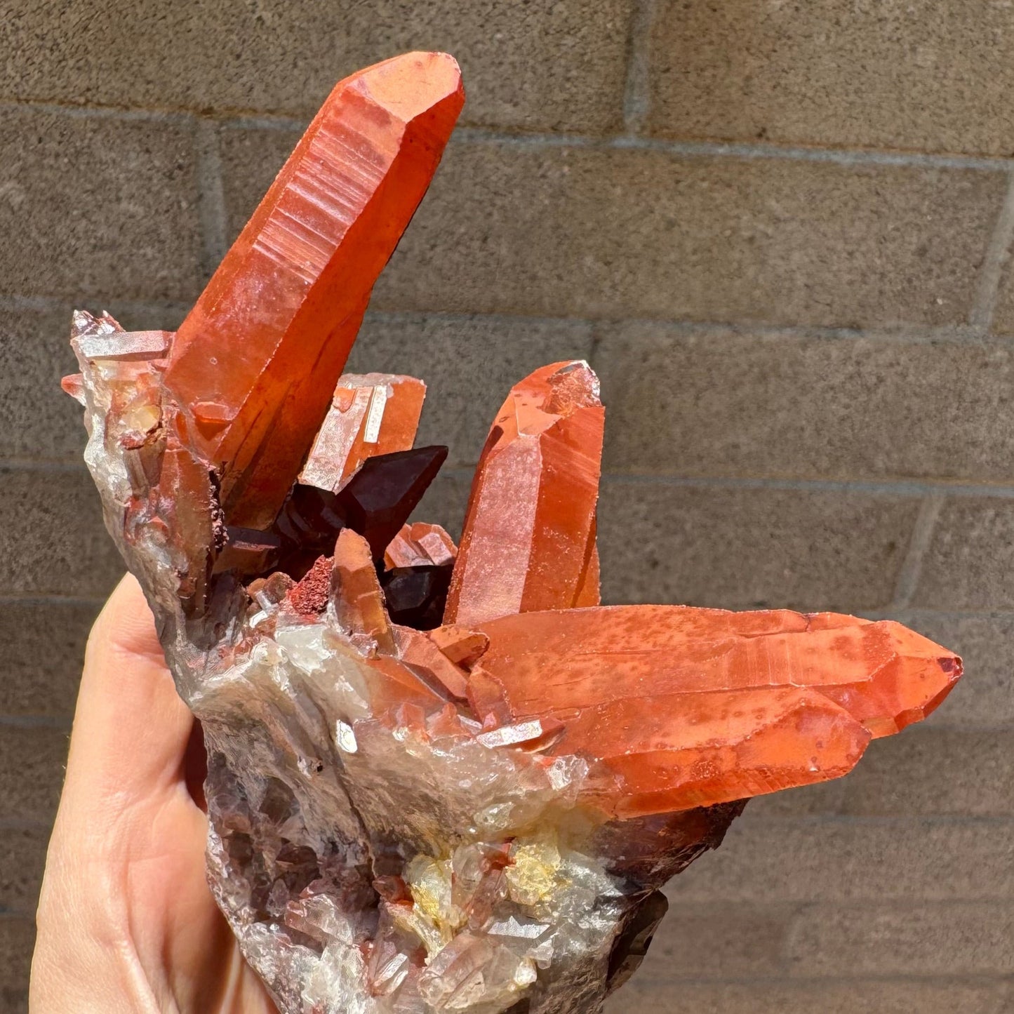 Another angle of the large points on the end of the specimen, a lighter orange-red color with one large point on the left and on the right a trio of points lined up as one flat crystal.