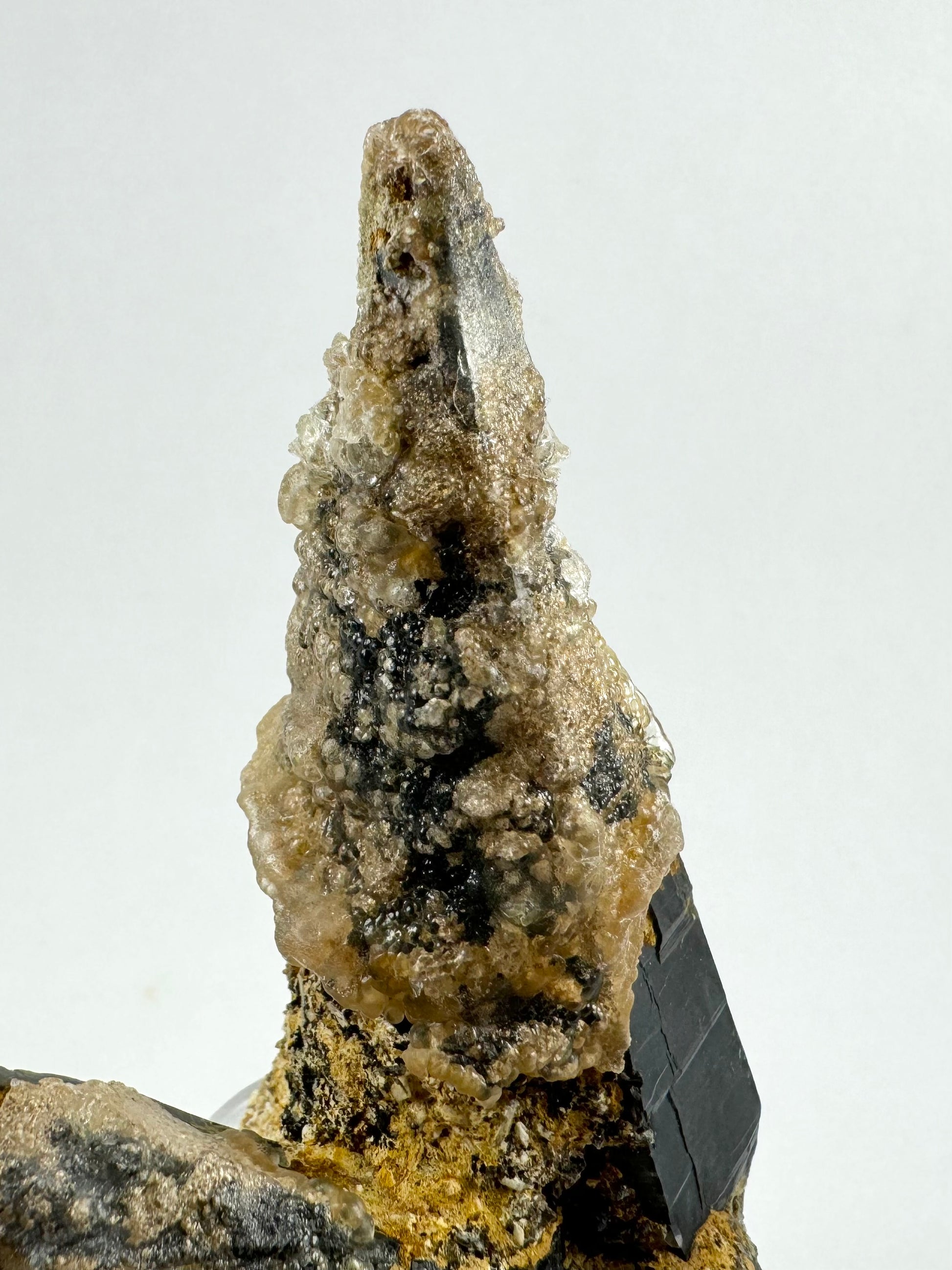 Detail of one side of the point, mostly covered in hyalite. There are nice growth forms on the quartz that is visible. The hyalite is a bit milky with and translucent compared to the usual clear glossy spheres.