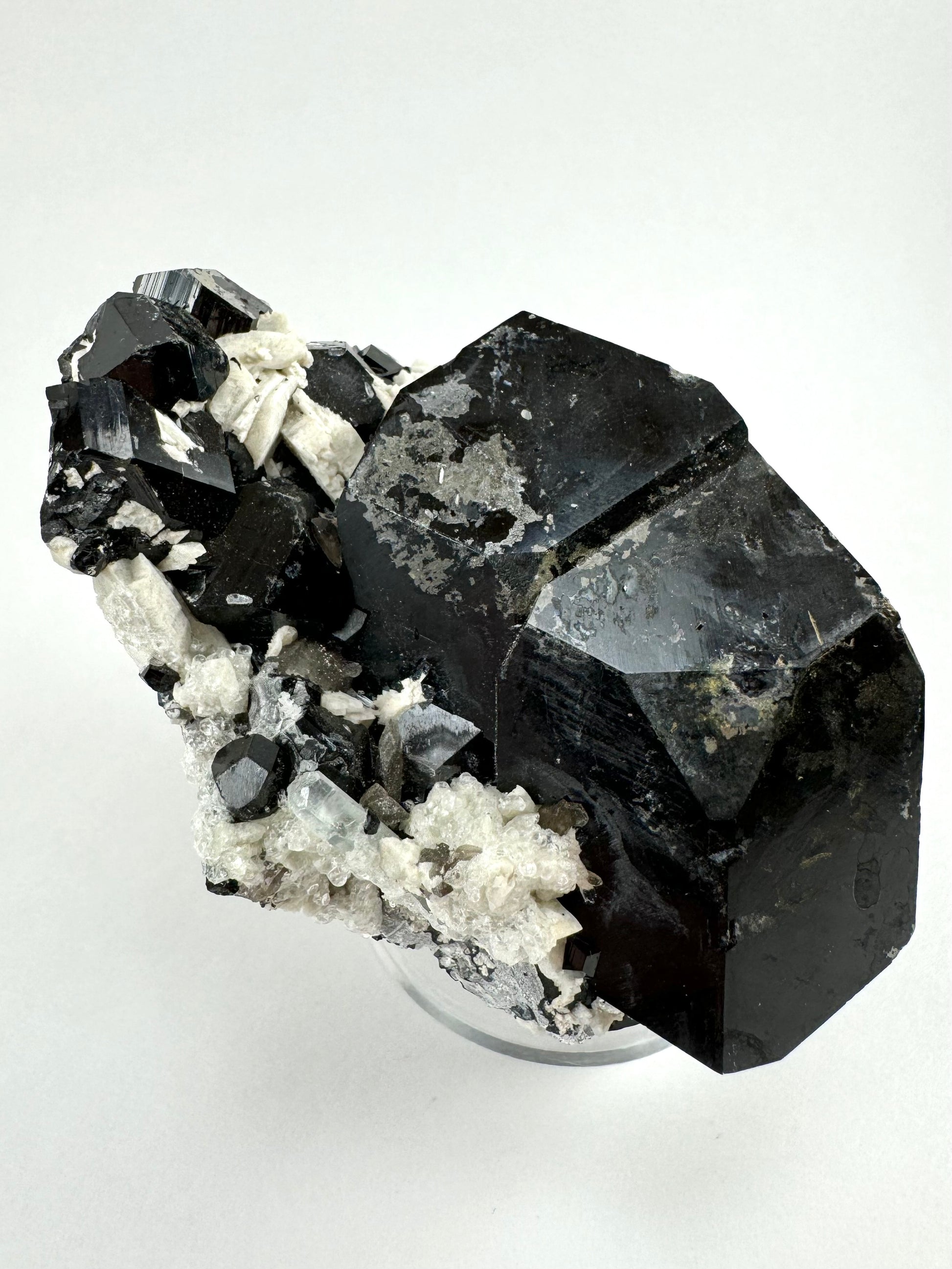 A wider view of the previous image, showing the luster is poor on this side of the schorl due to the overgrowth. The schorl crystals near the top have good striations.