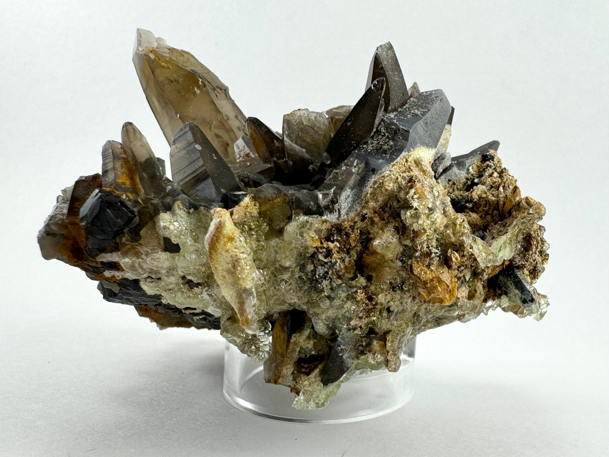 A side-view of the piece with the points jutting up and irregular mineral composite at the bottom. The hyalite is thick and has large spheres with good transparency.