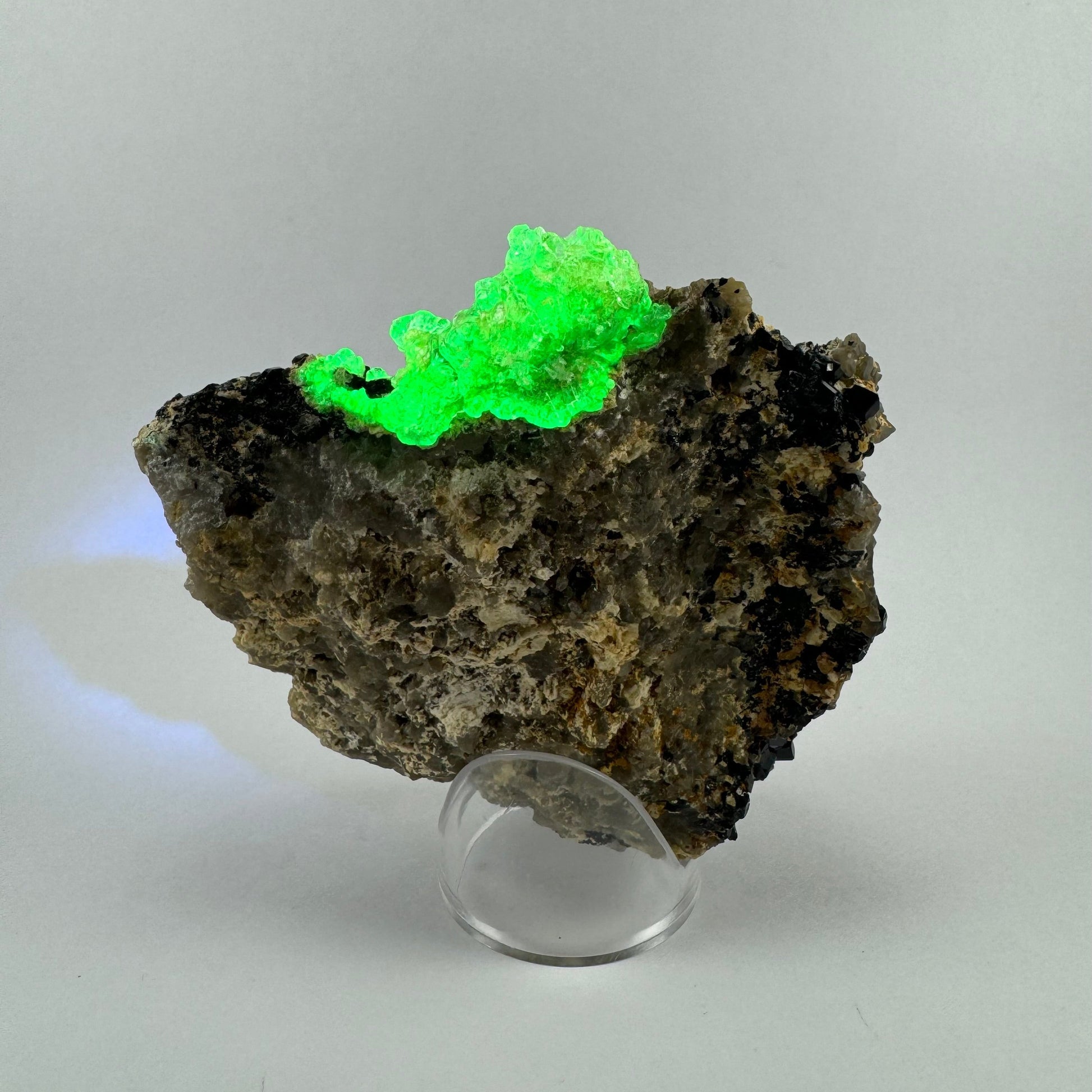 The specimen in the same position as the previous image, with the hyalite fluorescing vibrant yellow-green.