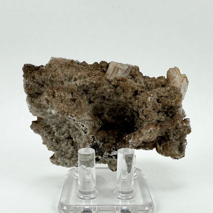 The full back of the specimen, covered with calcite druzy and with several well-formed hydroxyapophyllite crystals on the top. There is a dark cave-like indentation at the center.