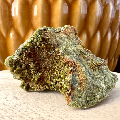 Detail inside one concave end of the piece, sprinkled with yellowish lighter olive green epidote crystals. The flat matrix on this side of the piece is mottled green.