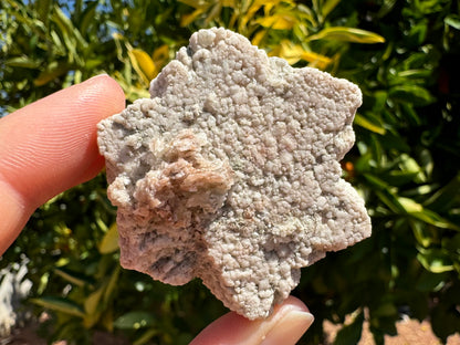 Closer view of the front of the piece, showing the surface texture. It is like cauliflower, as if the mineral is composed of small rounded pieces of aggregate. The irregular cluster on top is composed of flatter layered material.