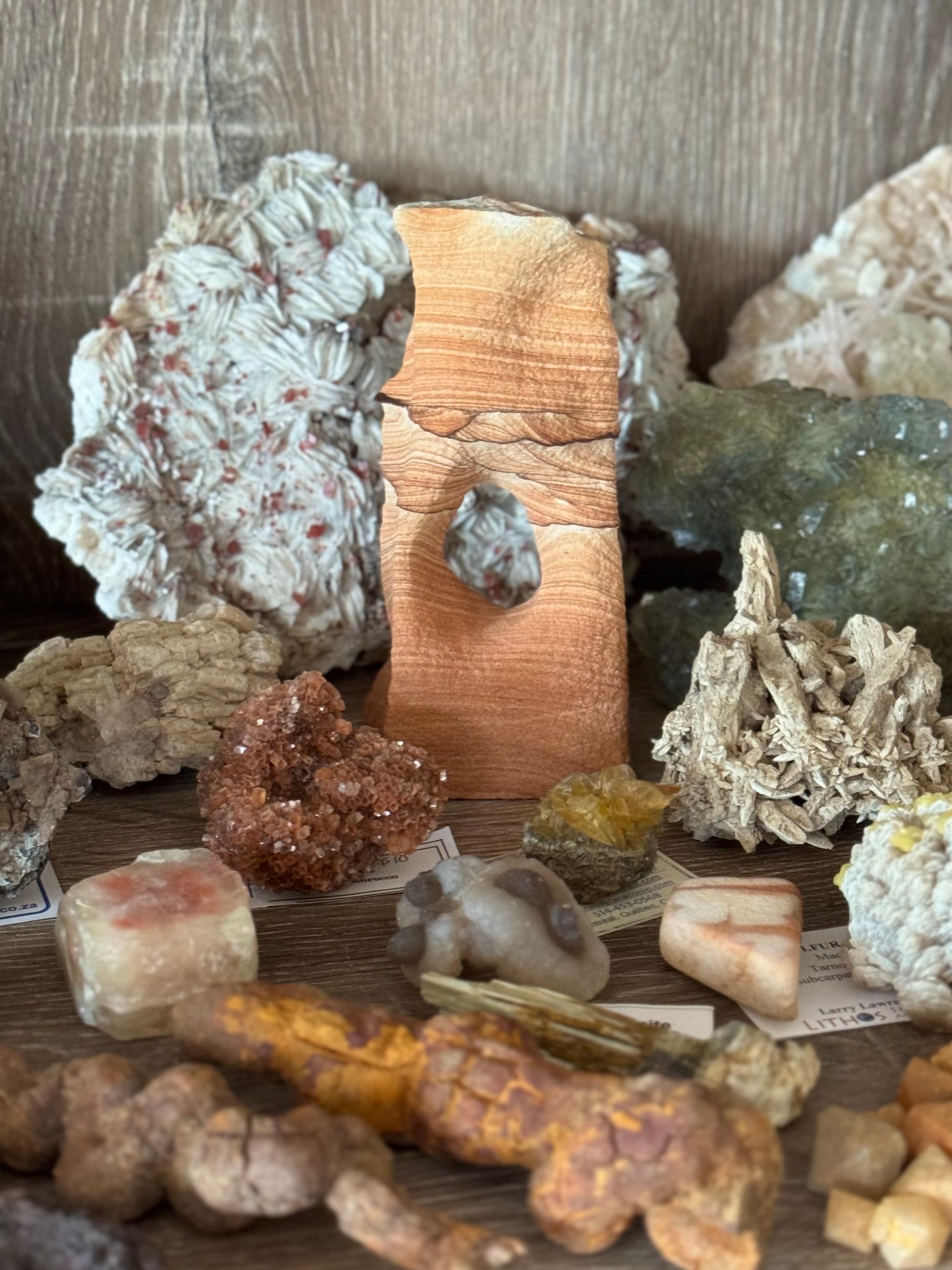 A tall narrow sandstone arch on a mineral shelf, showing relative size. The color is quite vibrant compared to other specimens.