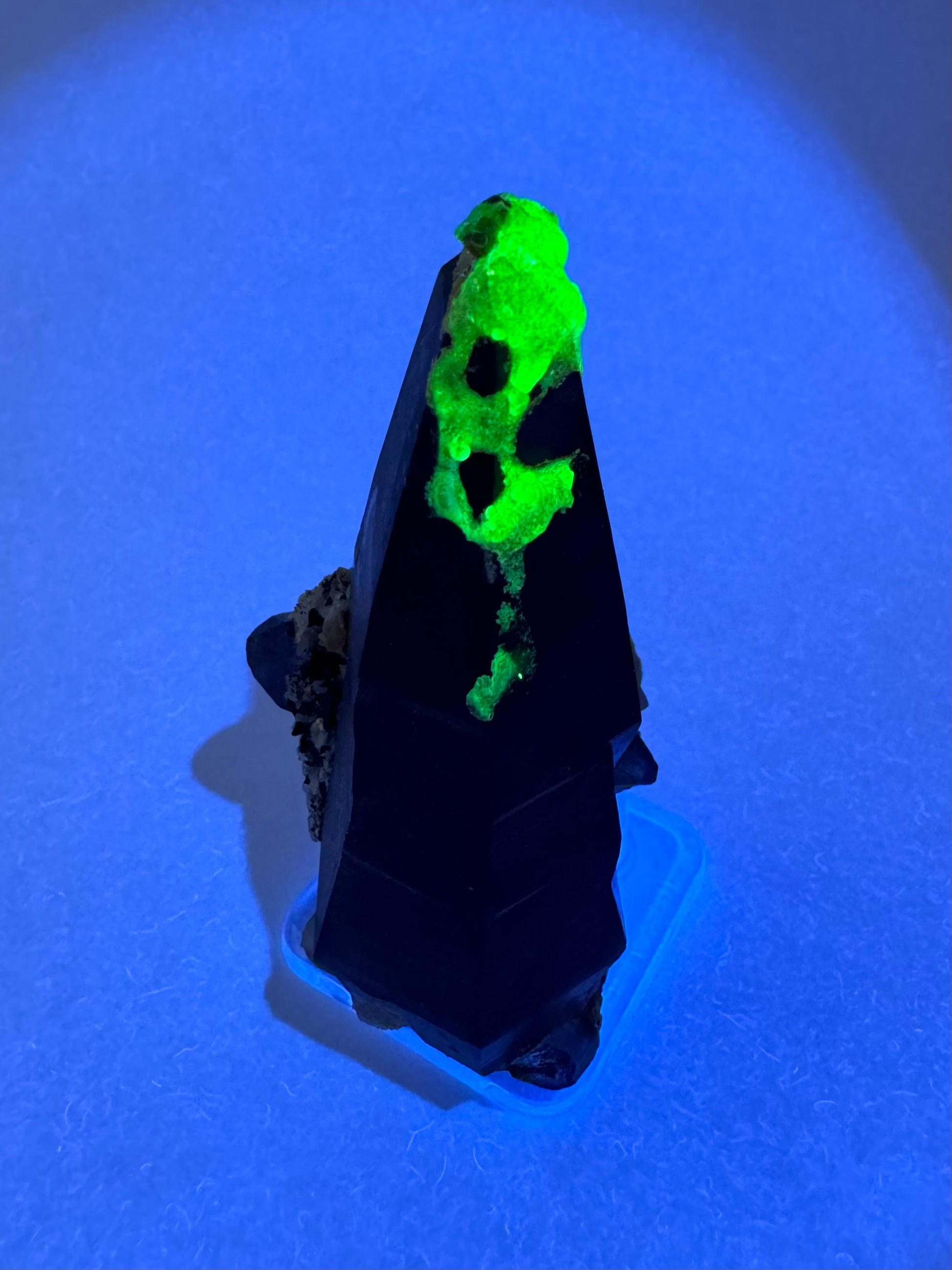 The third of three lighting images: the piece in the same position as the previous image, illuminated with UV light. The hyalite fluoresces a strong yellowish-green.