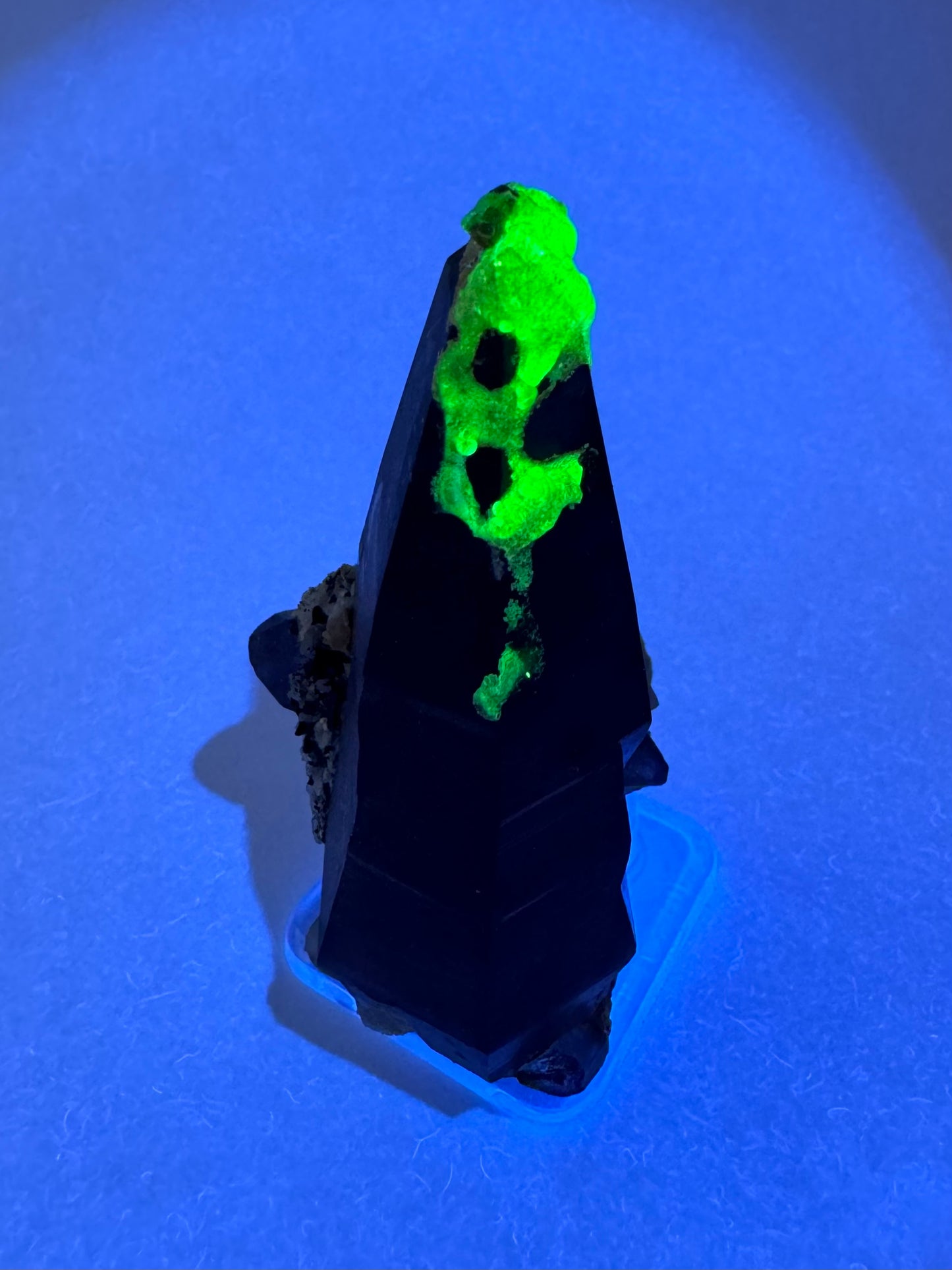 The third of three lighting images: the piece in the same position as the previous image, illuminated with UV light. The hyalite fluoresces a strong yellowish-green.