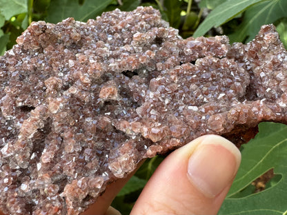 Detail of the calcite druzy at the edge of the piece, showing small caves and folds in the druzy.