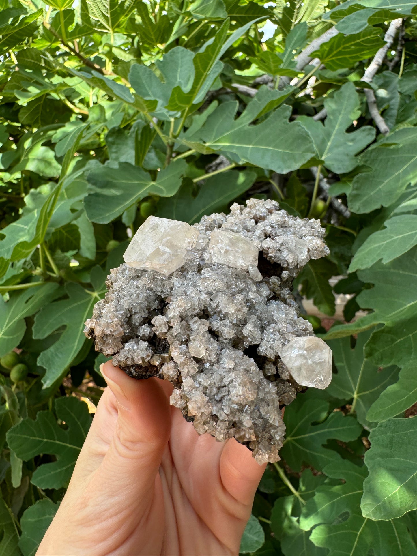 Angled view of the piece, showing druzy is thick and calcite crystals perched atop the piece.