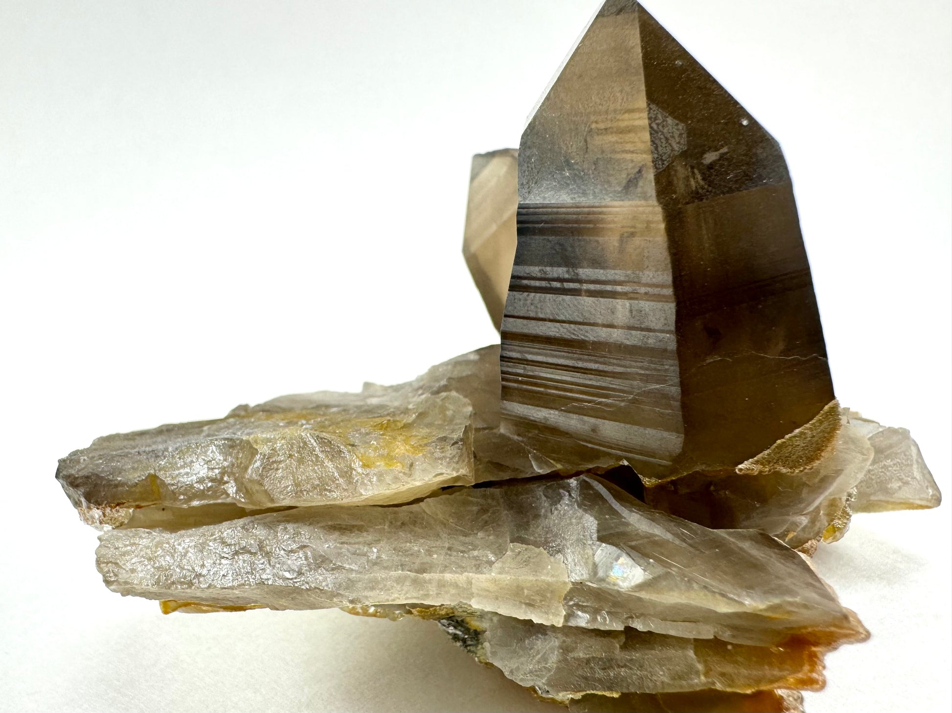 View of one end of the specimen, with layers of thin broken shards of smoky quartz forming the base under the two points.