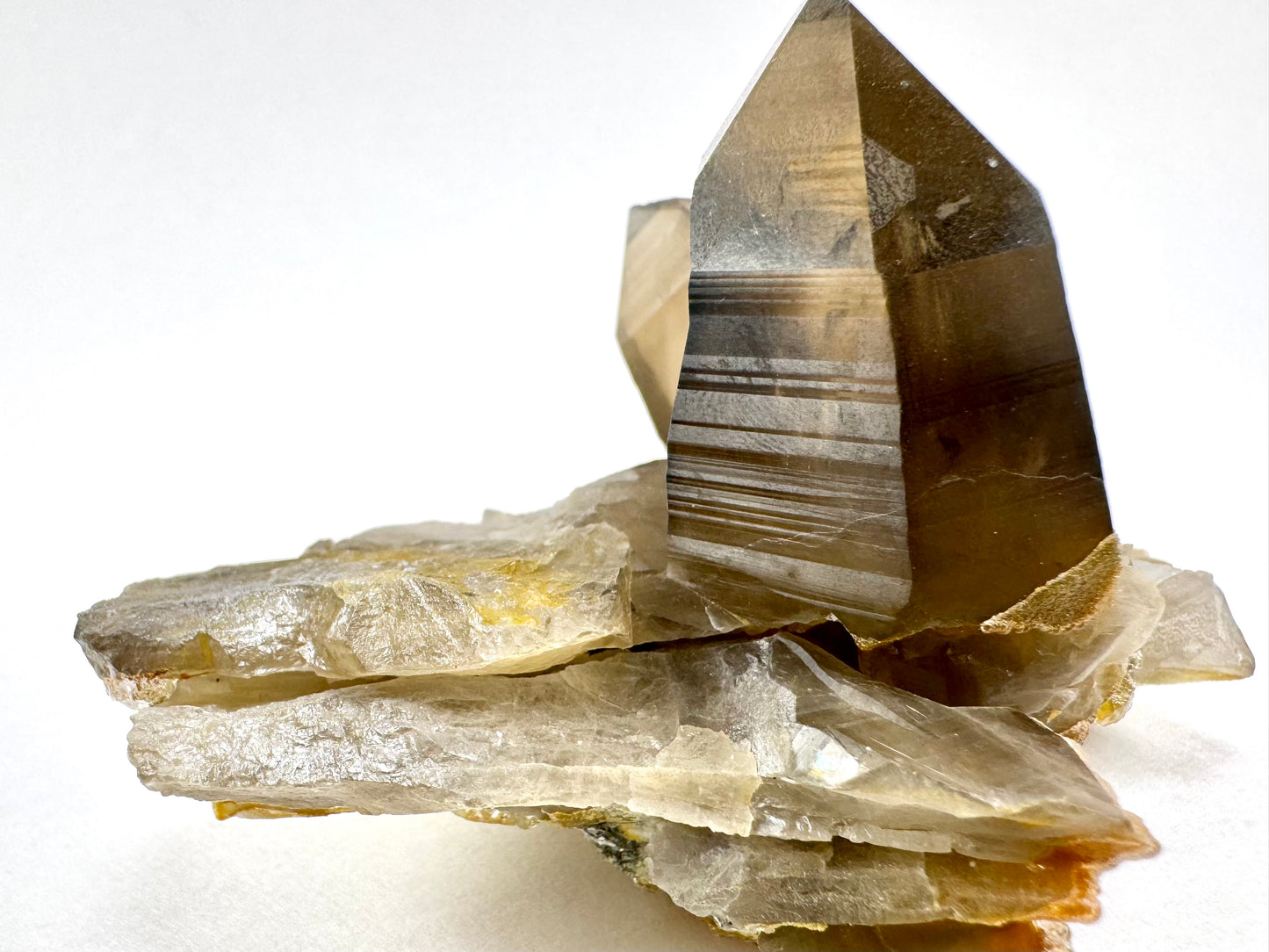 View of one end of the specimen, with layers of thin broken shards of smoky quartz forming the base under the two points.