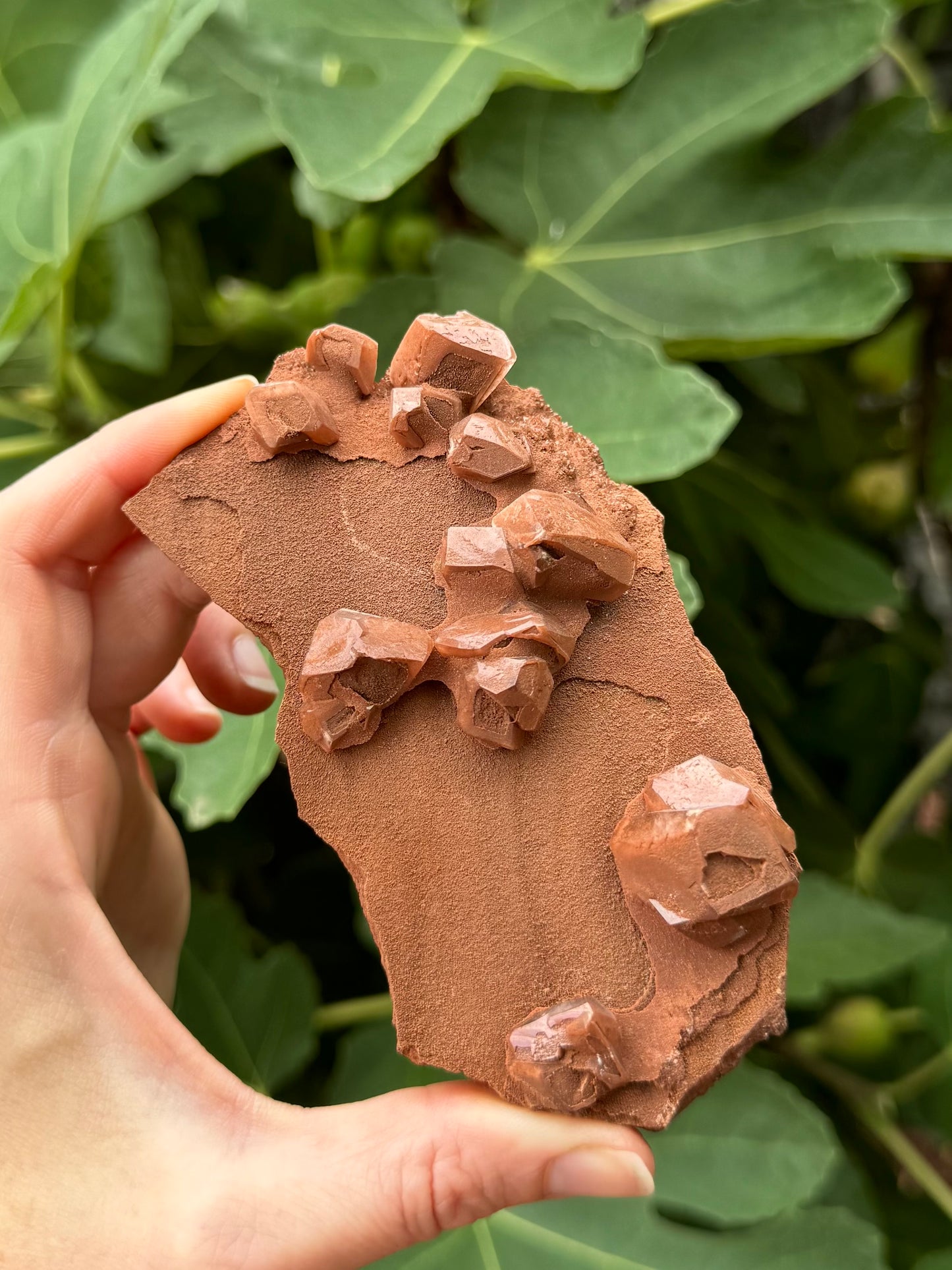 Angled view of the front of the piece, showing the modified rhombohedral structure of the calcite crystals. The surfaces reflect well, though the piece is largely matte with a sandy glitter.