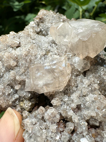 Closer detail of the two larger calcite crystals with light catching the internal features of the smaller one