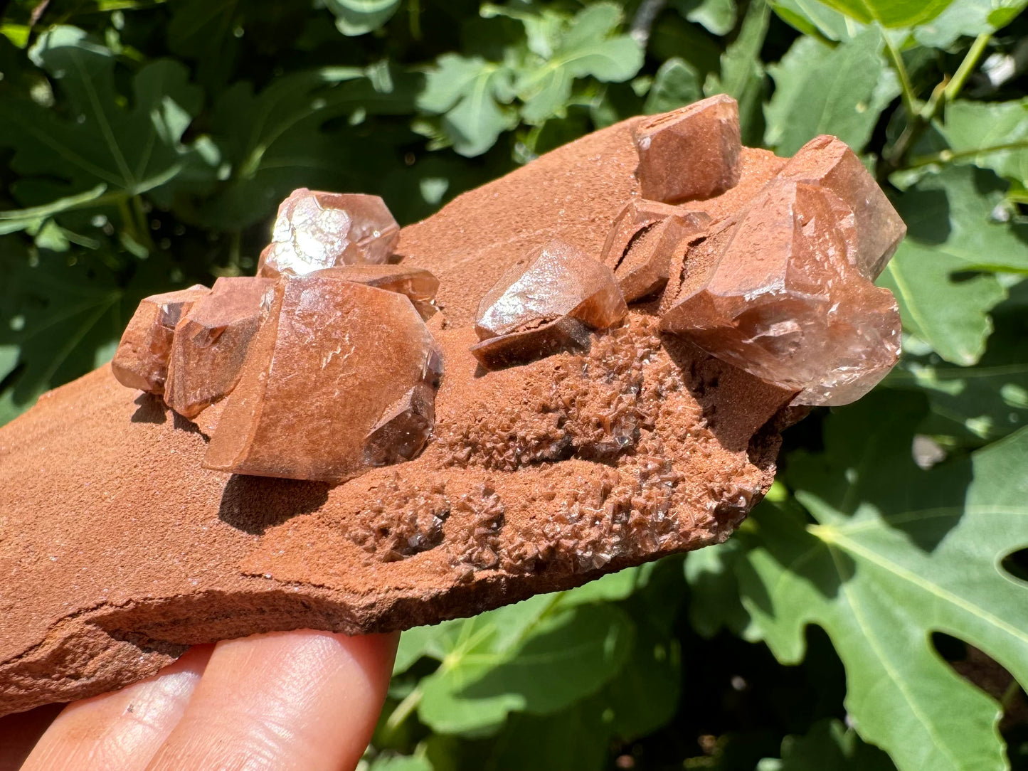 Detail of a cluster of pointed calcite crystals on the corner of the piece. The are composed of small intersecting pyramidal crystals, and coated with the sandy brown mineral.