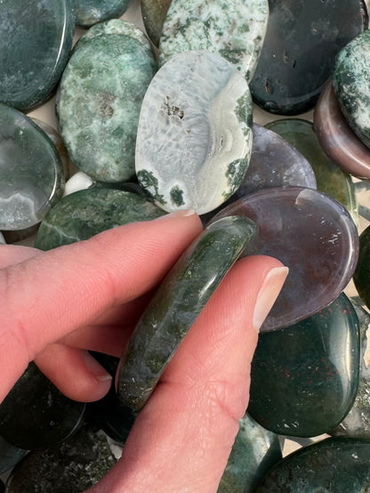 Side view of thickness of agate worry stones, about a quarter inch