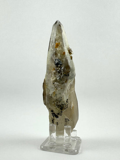 The back side of the piece, which is near-white mostly coated in fine hyalite. There are chunks of black and white minerals entrapped in the hyalite.