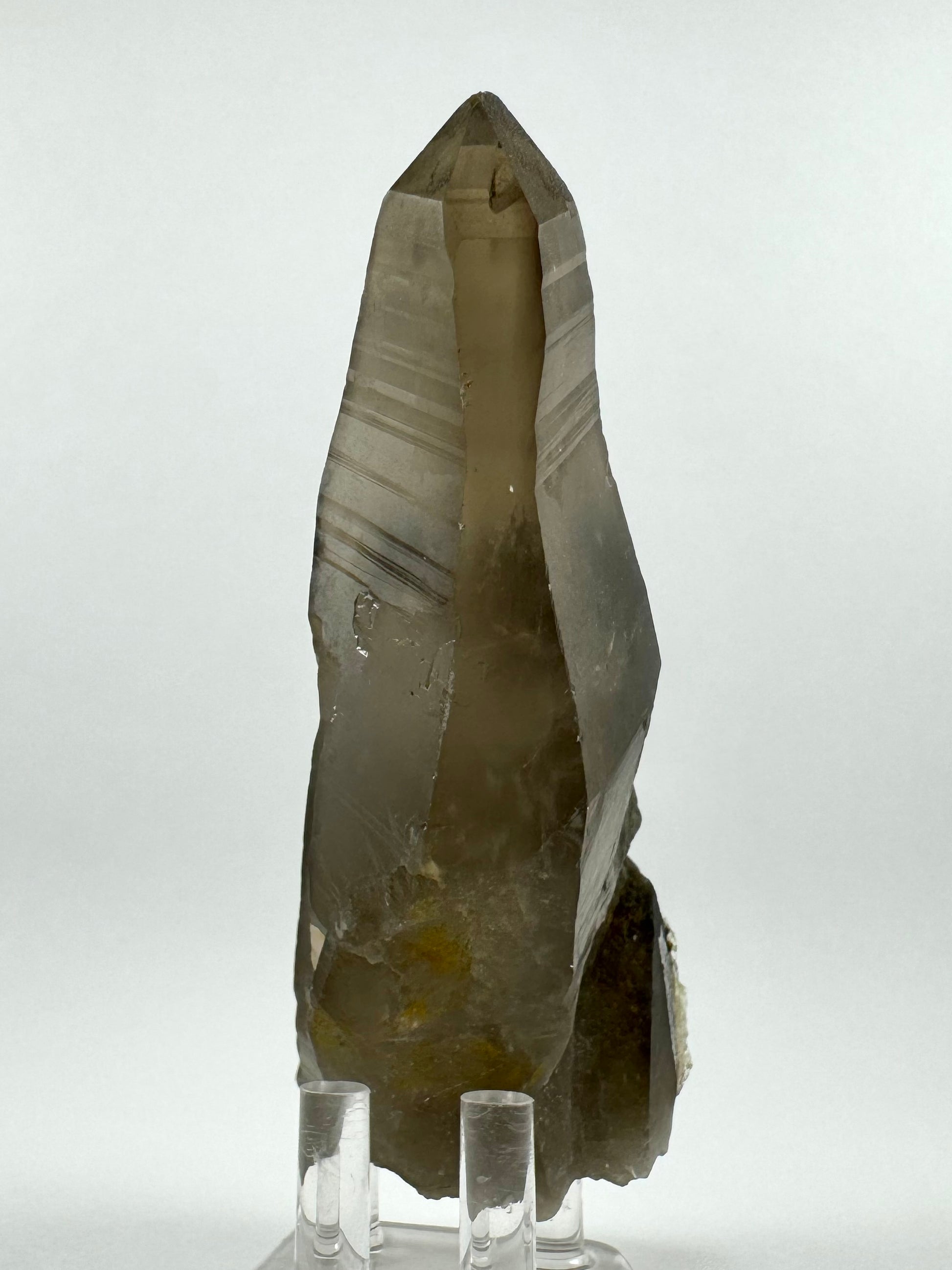 The back side of the point, clean of other minerals. This shows the smoky quartz is a lighter brown with even coloration. The faces of the point have good symmetry and horizontal growth striations