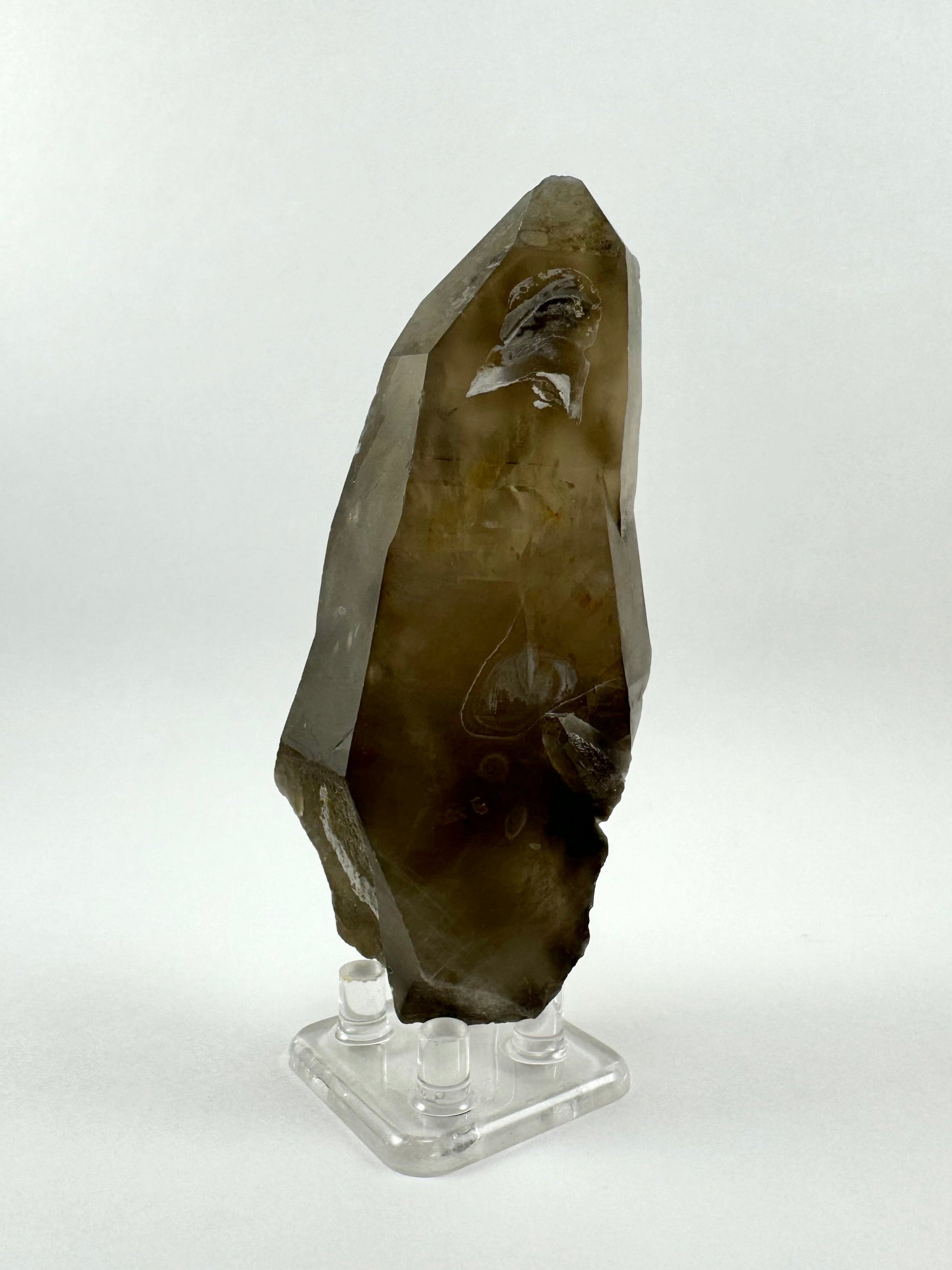 Another side of the piece, looking dark near the base but with the center looking quite clear and bright like inclusions within are catching light. The faces of the quartz are well-formed with angular bends