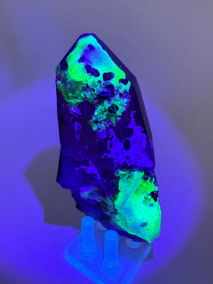 The third of three lighting images: the point in the same position as the previous image, in the dark and illuminated with blue-tinted UV light. The hyalite fluoresces a strong yellowish-green with light blue in patches.