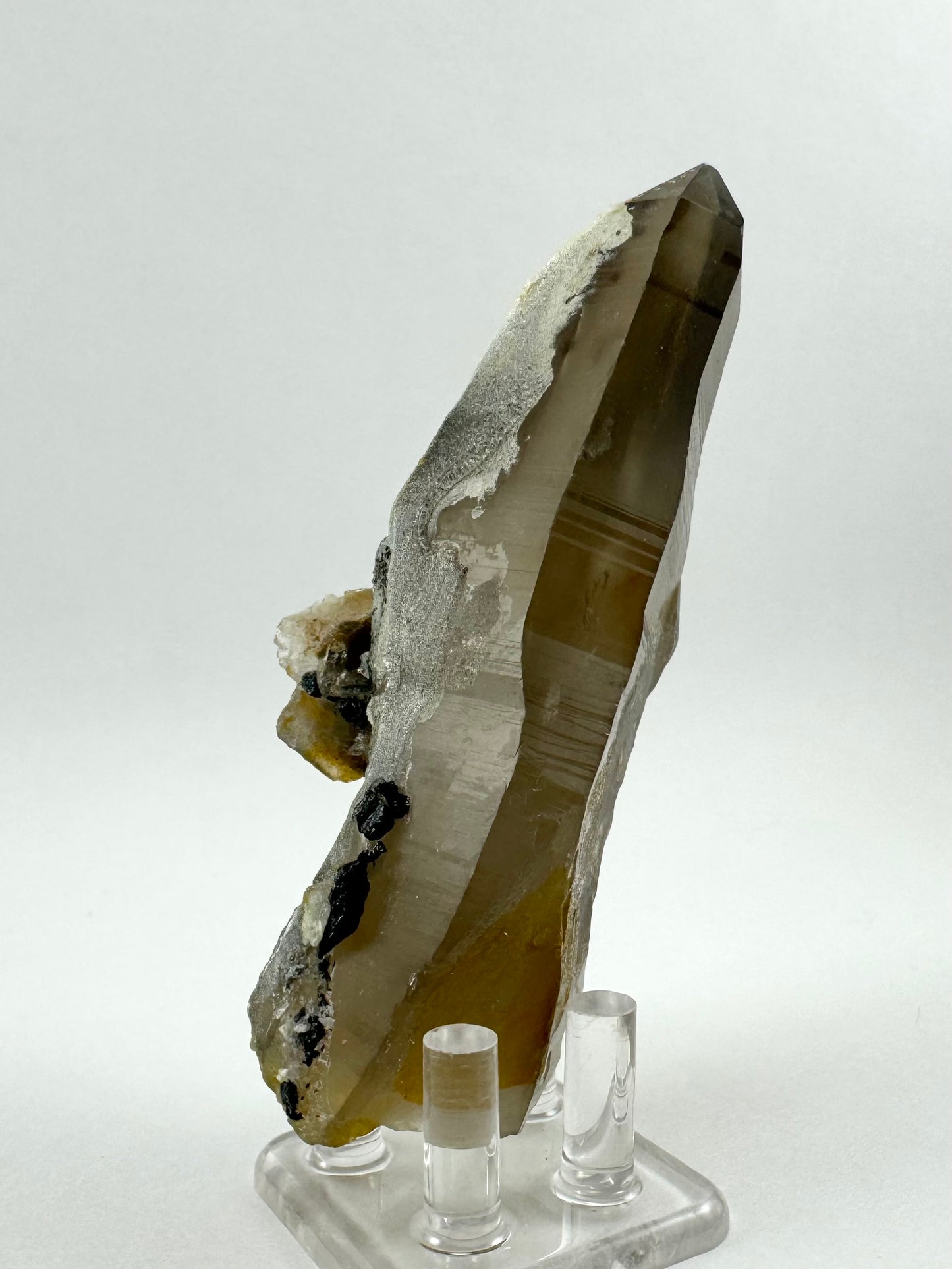 Another side of the piece, showing sleek long faces free of other minerals and slightly darker coloration near the tip of the smoky quartz