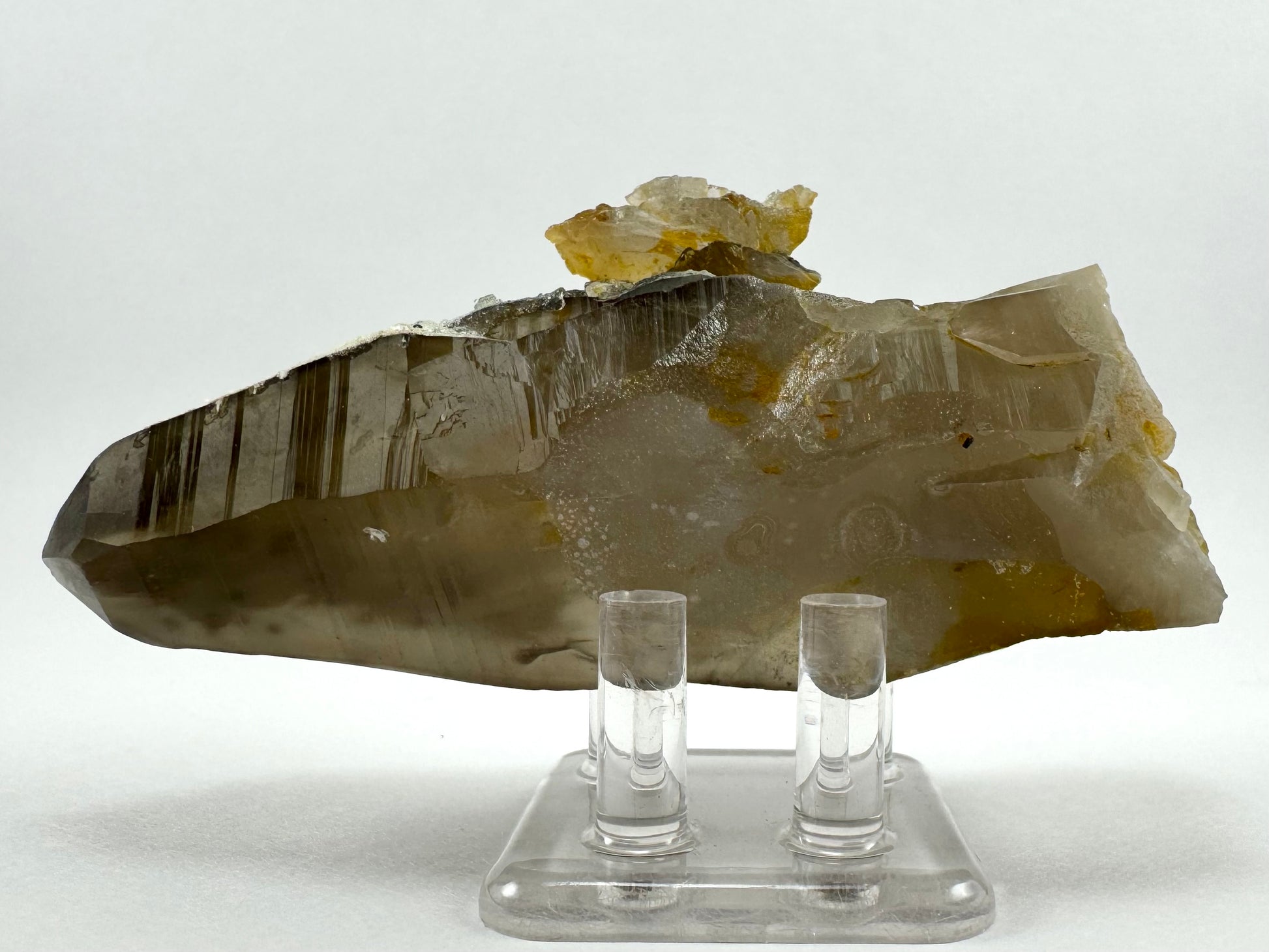 The point on its side, with reflections emphasizing the horizontal striations of growth lines down the face of the quartz.