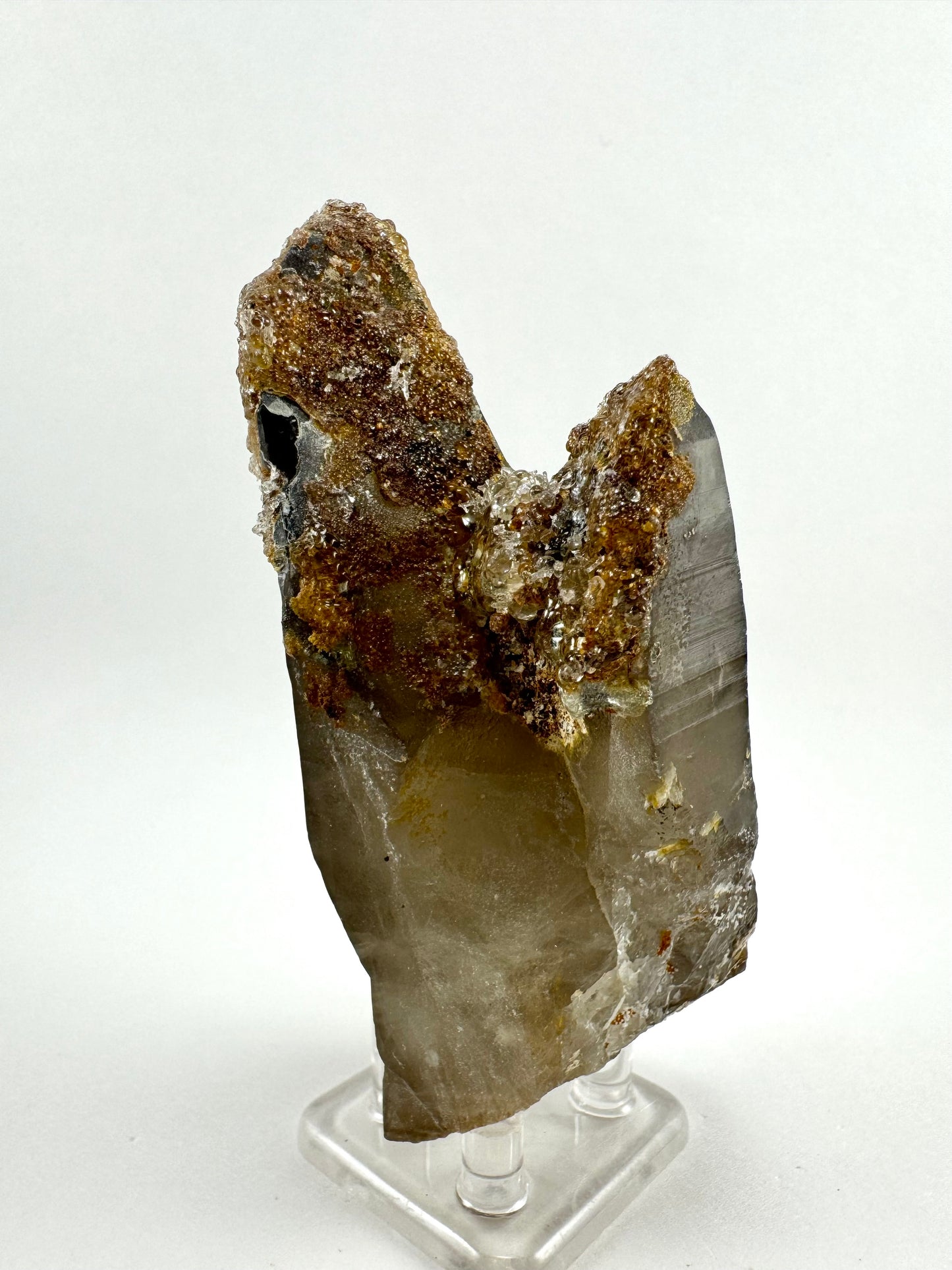 Side-view of the pair, largely covered with hyalite but with the far right side clear of it, revealing good crystal form.