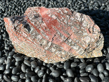 A rectangular side of the piece, with thick colorful veining diagonally across it. Veins are strongly red with gradient down to yellow.