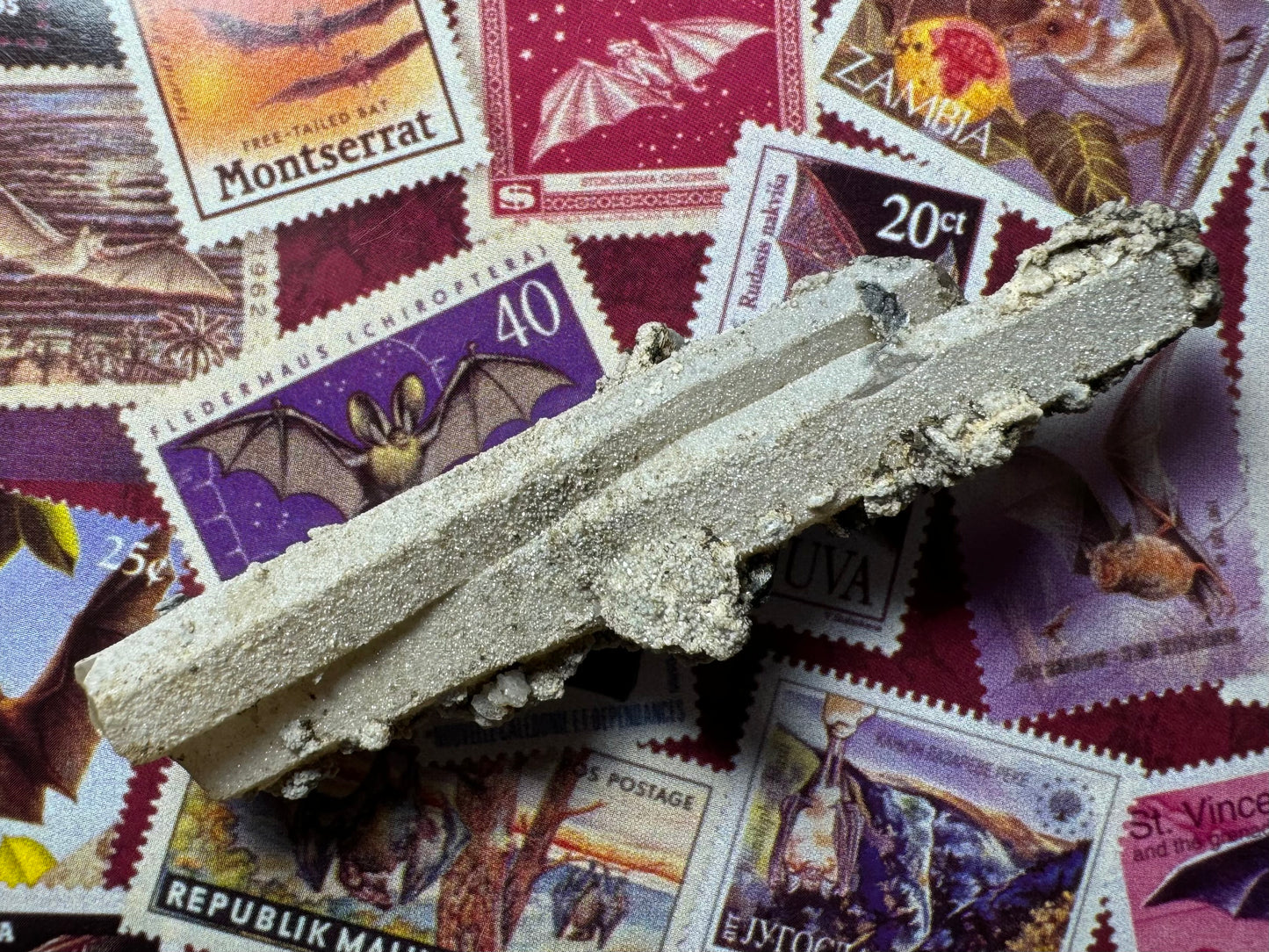 Closer view of the front of the points angled in the light, showing excellent quartz shape. The white crust glitters slightly like sand.