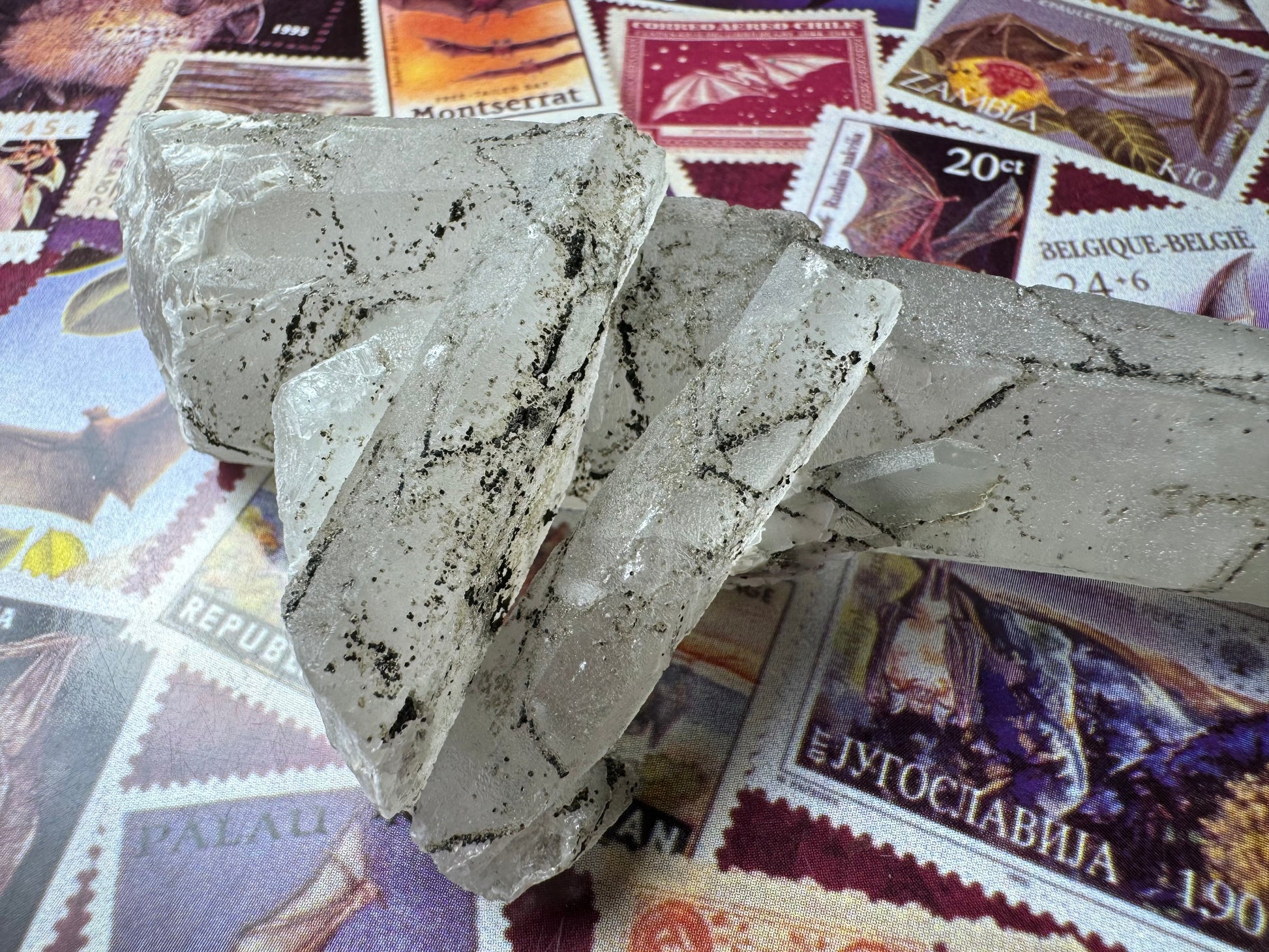 Another view of the pair of crystals, revealing there is a smaller point on the piece behind them, with tip intact. The base has web-like white calcite growth.