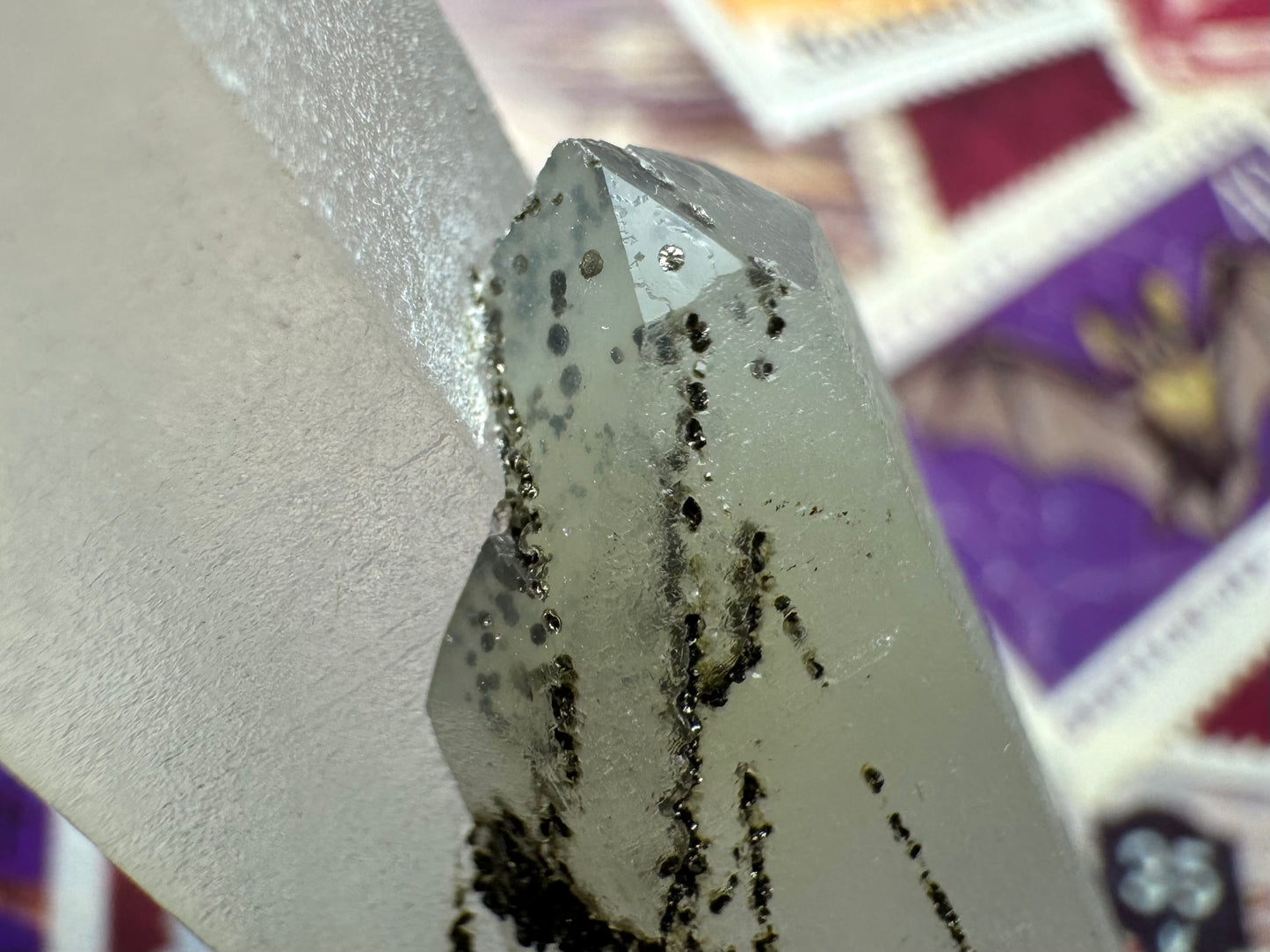 Detail of the smaller point, showing the black lines are composed of small radial-growth spheres grown into the surface of the quartz, in a dark olive-green tinted black color.