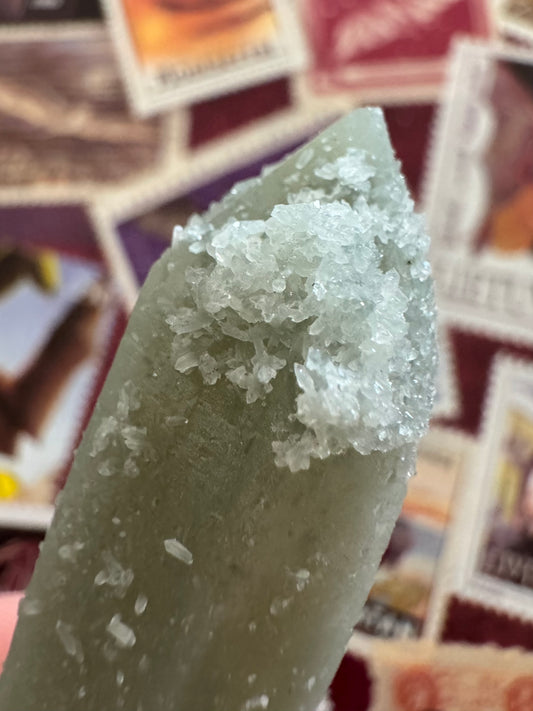 Detail of a cluster of white crystals on the tip of the point, small double-terminated quartz crystals like rice grains.