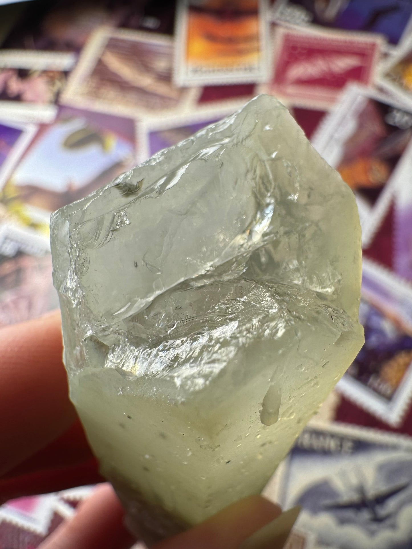 Detail of the broken end of the point showing the interior is glassy and colorless and there is a frosty crust