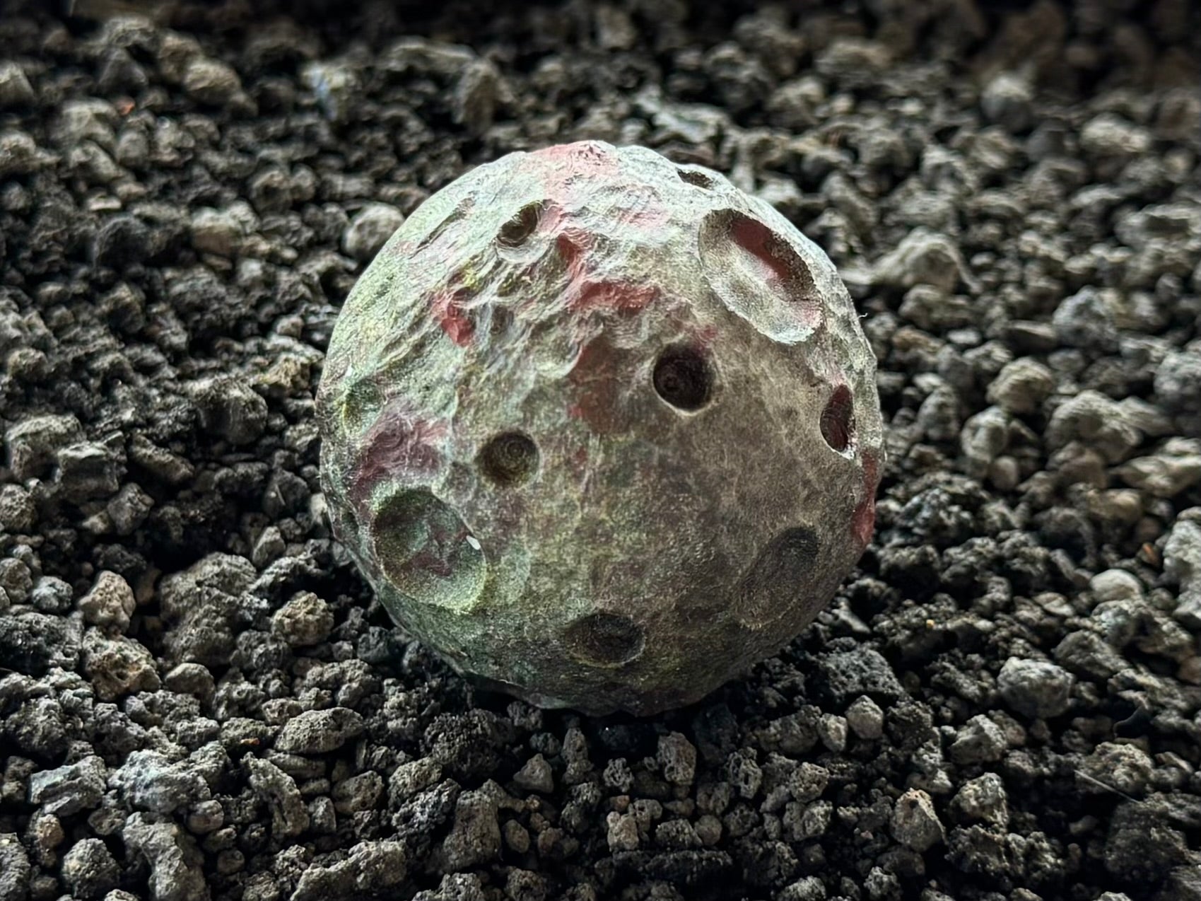 Detail of one of the moons on its own, with light emphasizing the craters on the surface.