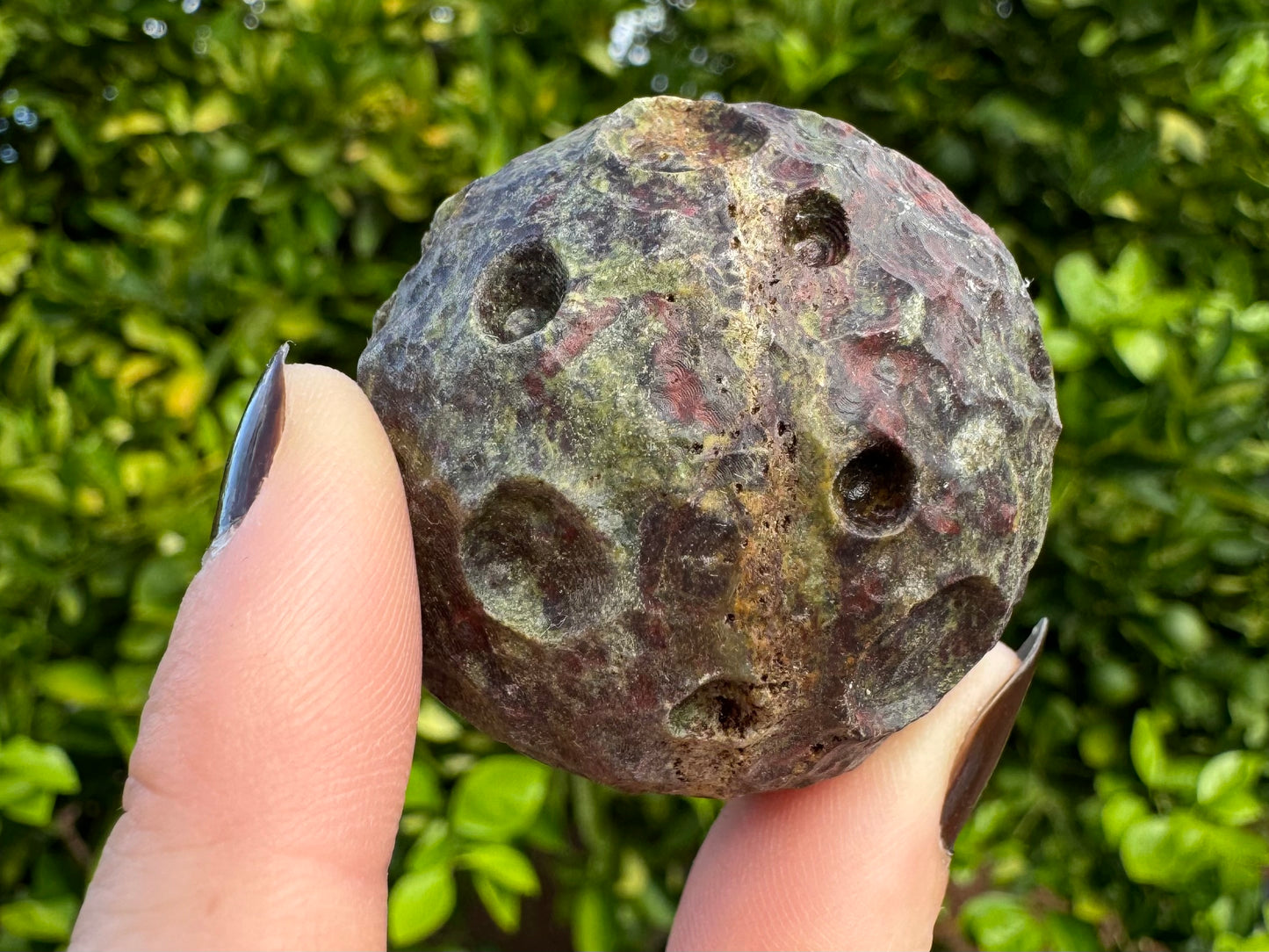 Detail of the same moon from the previous image, tilted so the light stripe goes diagonally across the bottom. It has porous holes in the stripe.