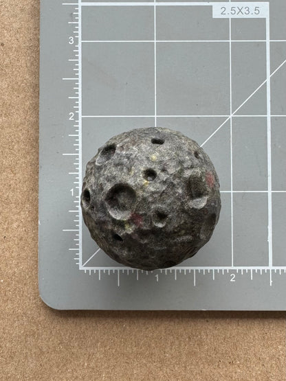 Scale image showing one of the moons on the measuring mat, a bit over an inch and a half.