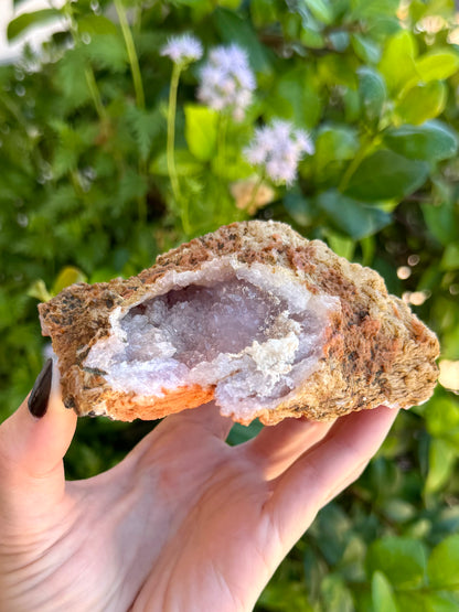 Looking into the open white geode on the back of the mineral at an angle.