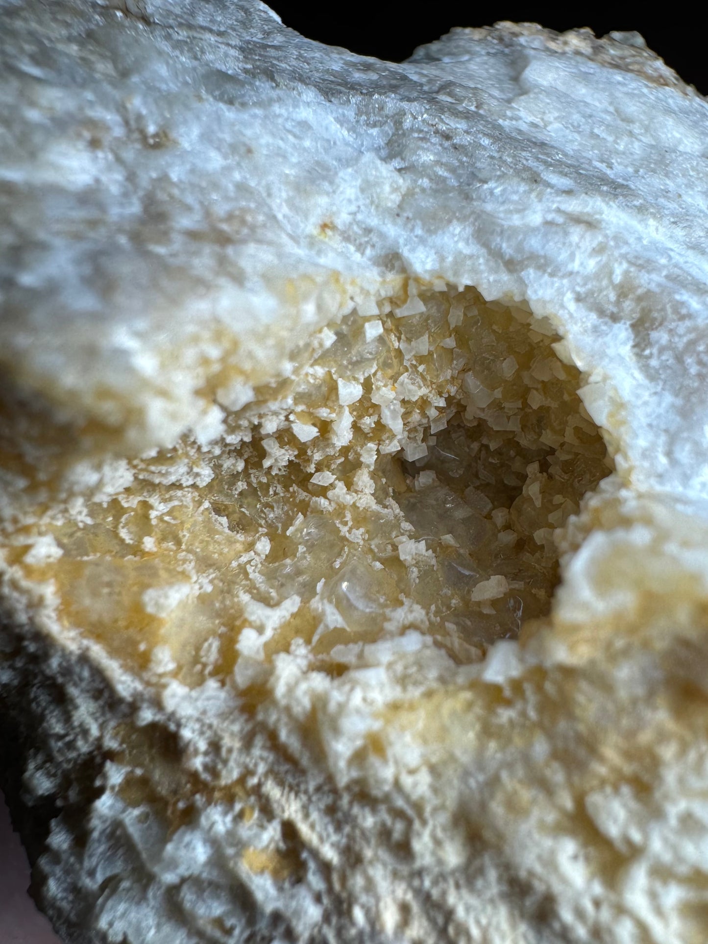 Detail of the crystal pocket on the back of the specimen, with small white rhombs scattered among irregular glassy crystal growth.