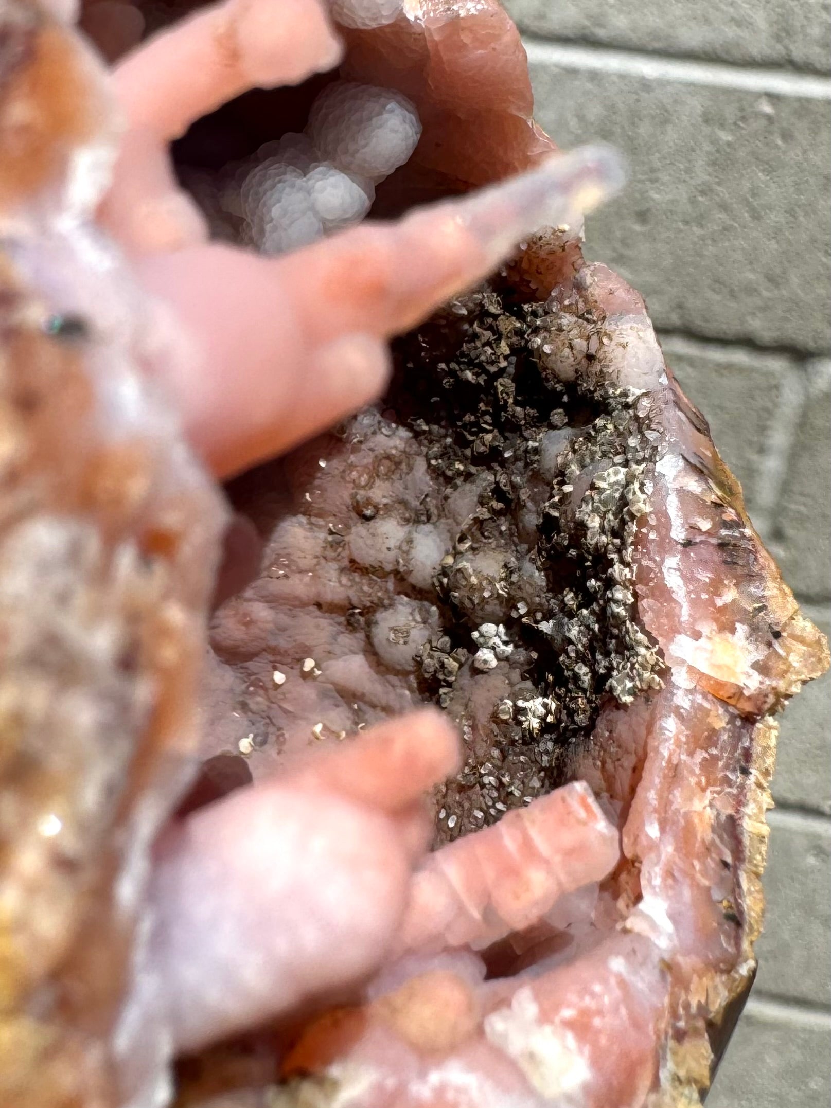 Detail of a matte brown mineral growing in small angular crystals on the roof of the geode