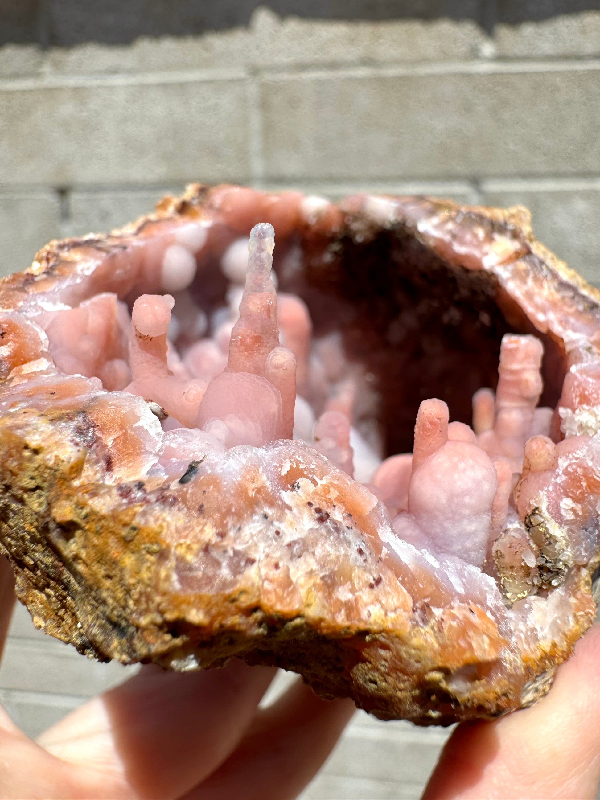 Detail of the stalactitic growth on one edge, with the candy cane formation and a tall spire that is colorless in the end and light orange in the base.