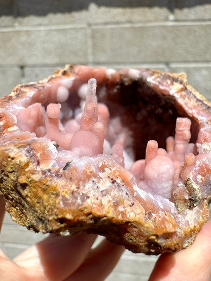 Detail of the stalactitic growth on one edge, with the candy cane formation and a tall spire that is colorless in the end and light orange in the base.